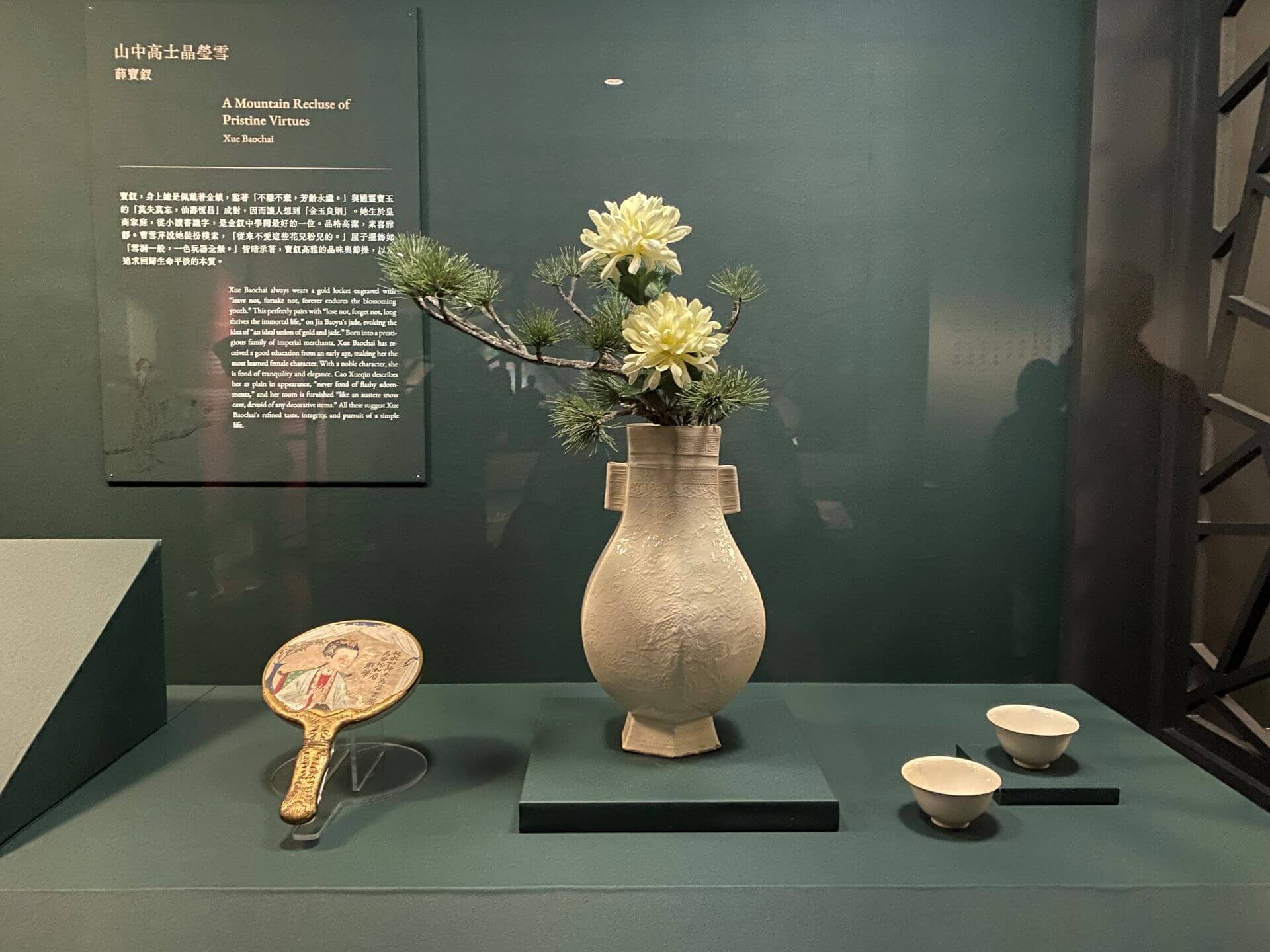 曹雪芹筆下的薛寶釵裝扮樸素，房間如「雪洞一般」，桌上只擺一個土定瓶（仿定窯白瓶），瓶中供著數枝菊。展出的明晚期至清《白瓷印花雲龍紋貫耳六方壺》，土定瓶及胎質粗鬆、釉色牙黃，一種模仿定窯的白瓷器，但氣質樸拙，帶土氣。（攝影／朱佑霖）