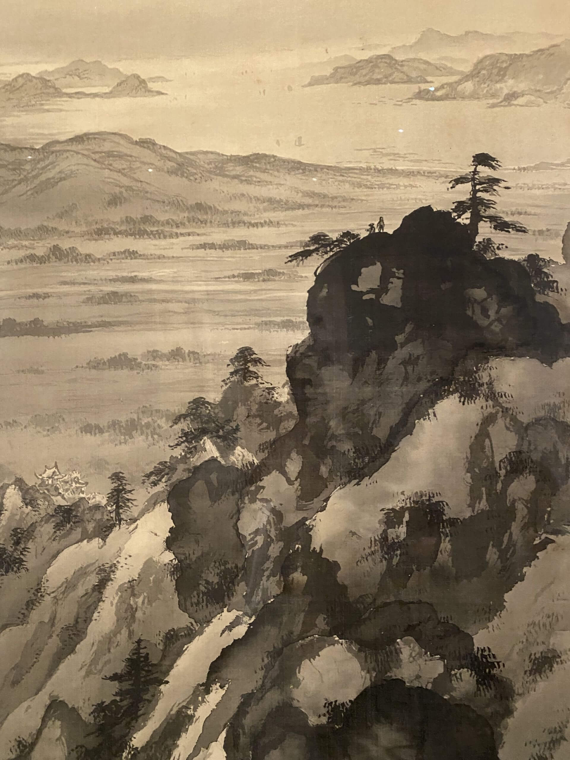 《彈琴臺》局部，畫家以水墨為媒材，運用暈染墨塊呈現山石與樹叢的造型，再以淡墨細筆勾勒植被、建築與點景人物，兼具寫實與意象的表現手法。（攝影／劉錡豫）
