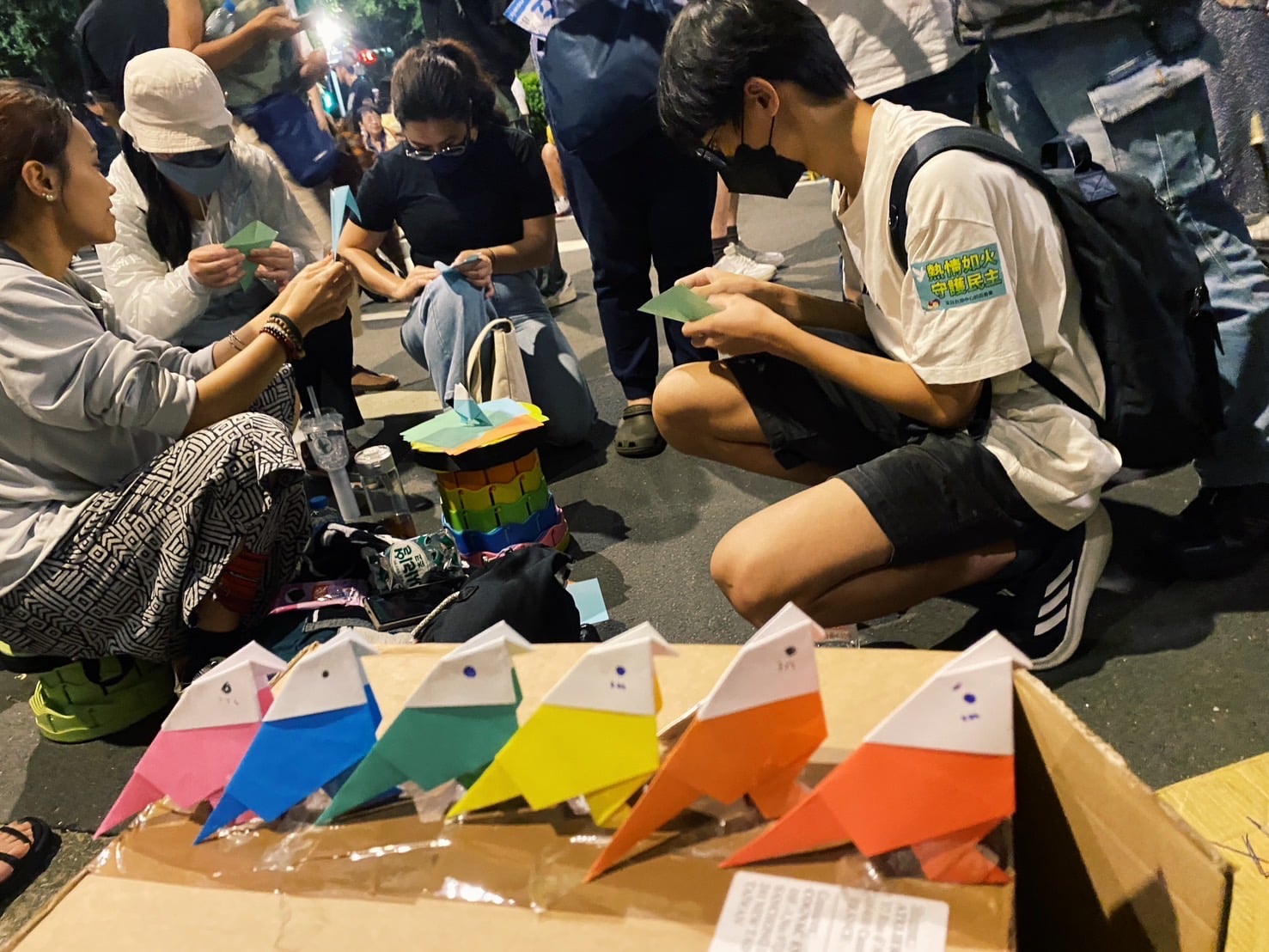 摺紙青鳥的發起人不是手工藝或藝術創作者。他在現場擺了攤位,教了某幾個人,而某幾個人又自發性地教起那些因路過而感興趣的人們,慢慢擴散成幾個圍圈手作的工作小組。(攝影/陳晞)