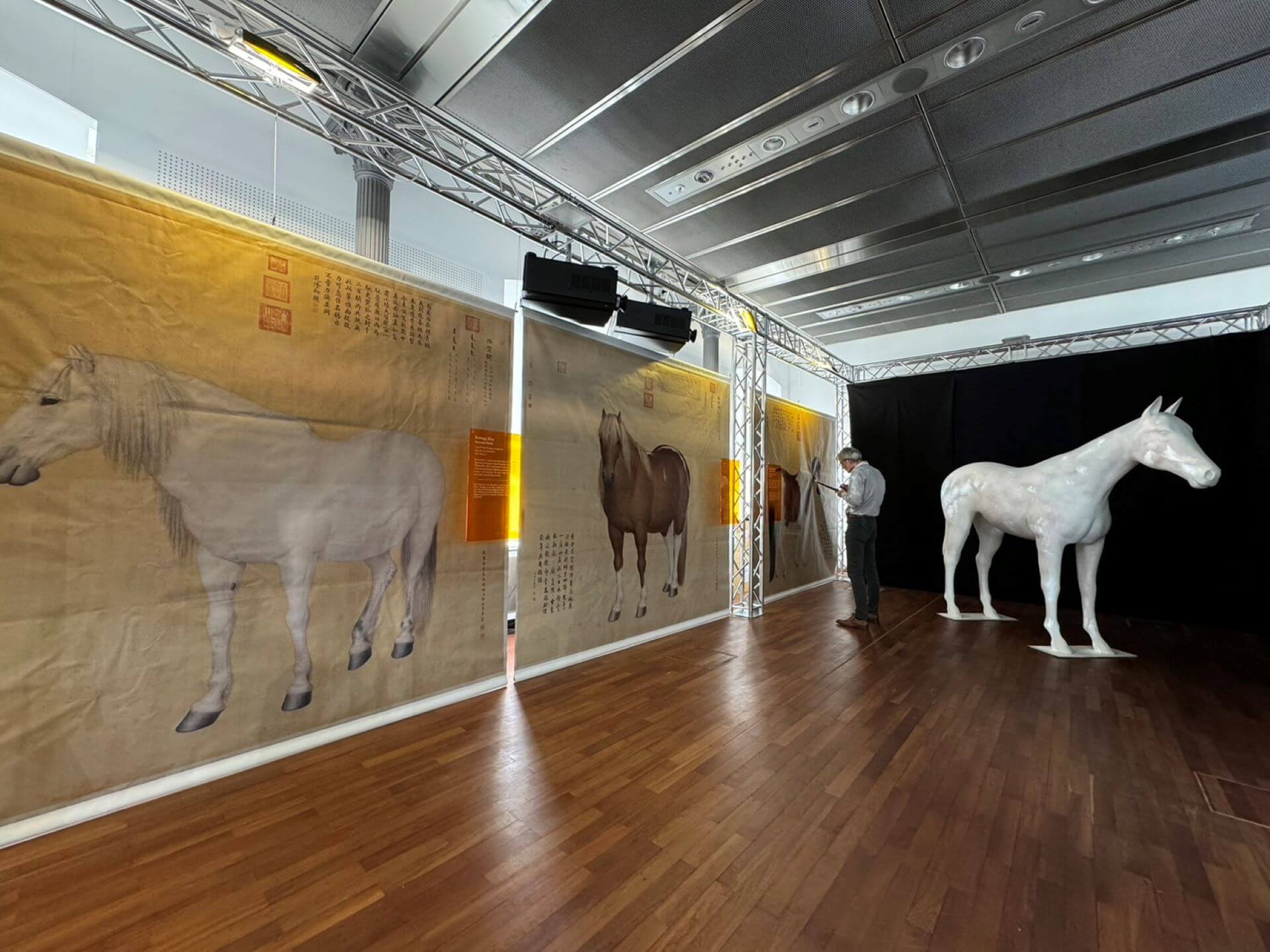 2024歐洲台灣形象展故宮展位展出《十駿圖》高仿真輸出畫作(左)與「百駿變」數位光雕(右)。（國立故宮博物院提供）