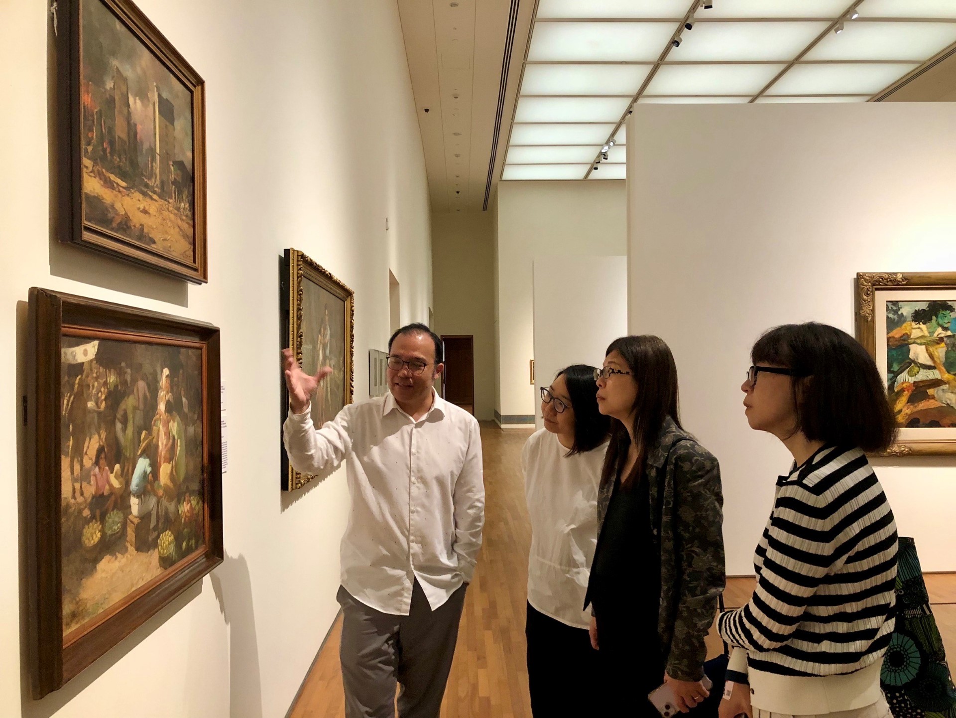 新加坡國家美術館資深策展人辛友仁（左1）為國美館館長陳貺怡（右2）一行解說作品情形。（國立臺灣美術館提供）