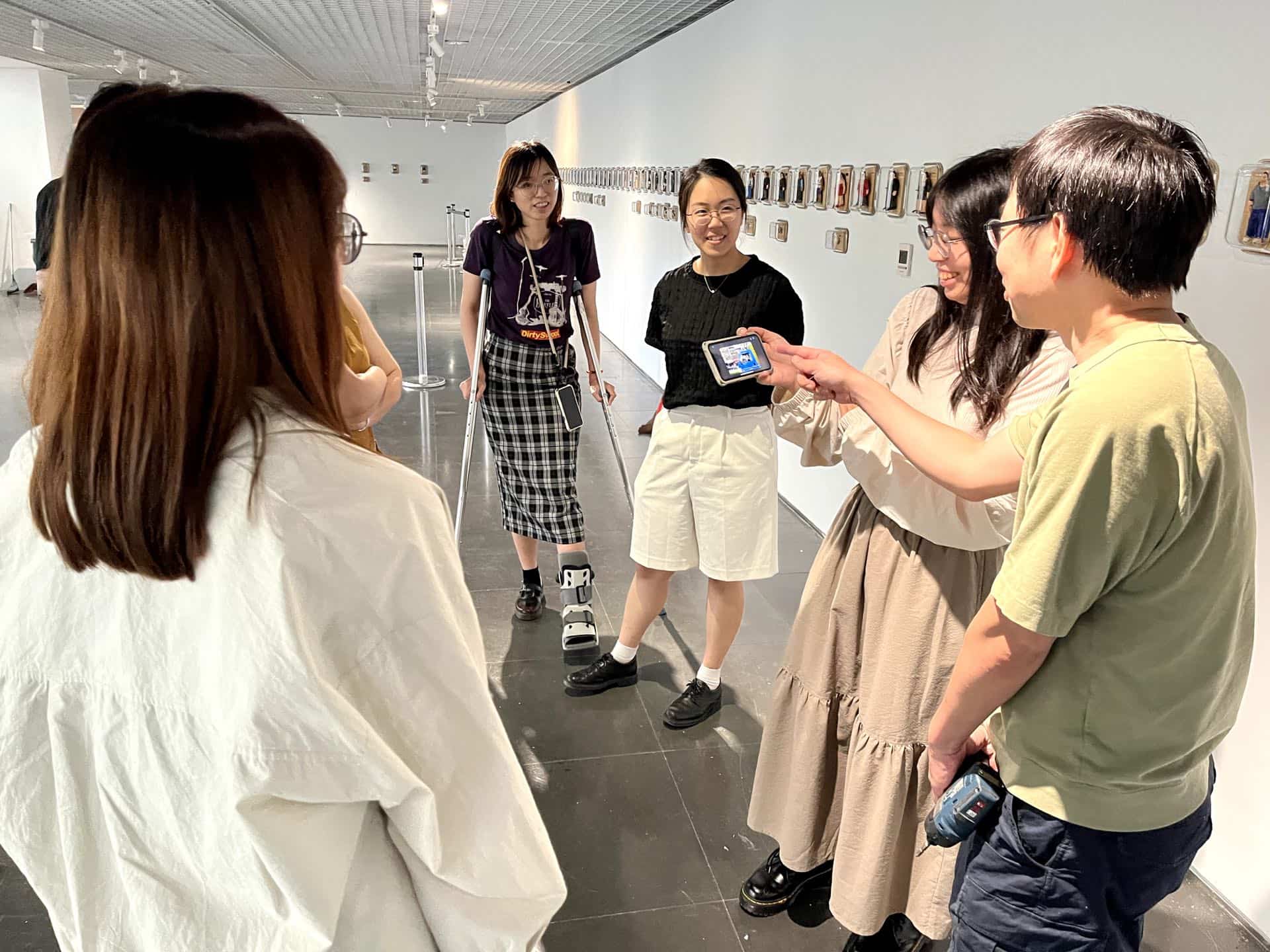 館員俐臻展示她自行製作動畫的展覽前導片「『戰鬥之城．終』外傳的外傳 」給原作者觀看。4月16日。（攝影／謝鎮逸）