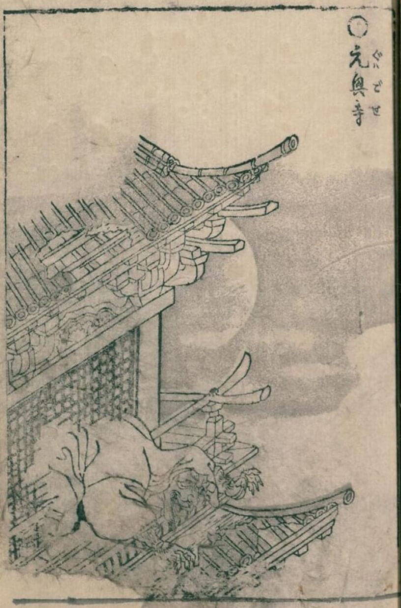 披著長袍雙眼突出、張著血盆大口滿嘴黑色尖牙的鬼怪，自一棟屋瓦破舊的建築物二樓破窗而出。鳥山石燕，《畫圖百鬼夜行 前篇風》〈元興寺〉。（©國立國會圖書館）
