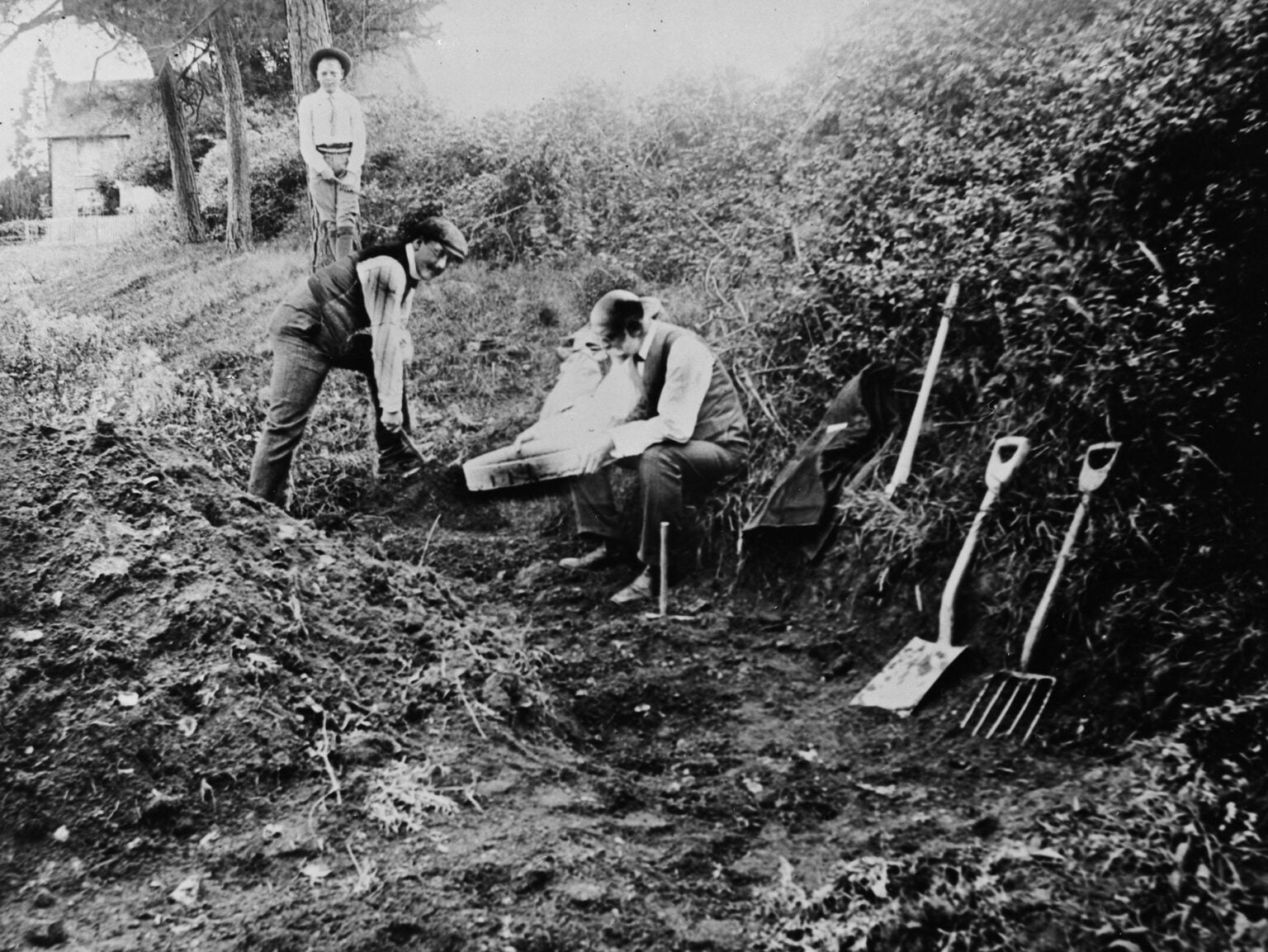1913年，查爾斯·道森（中）和阿瑟·史密斯·伍德沃德（右）在皮爾當遺址進行挖掘工作。（圖／Natural History Museum，Alamy Stock Photo）