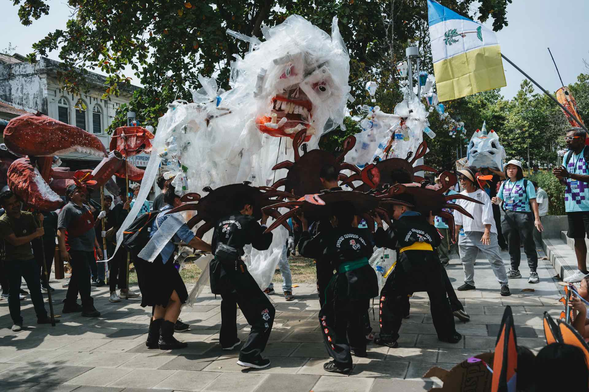 喬治市藝術節社區計畫的巨偶踩街遊行；龐大的垃圾怪與海洋的小螃蟹們。（喬治市藝術節提供）