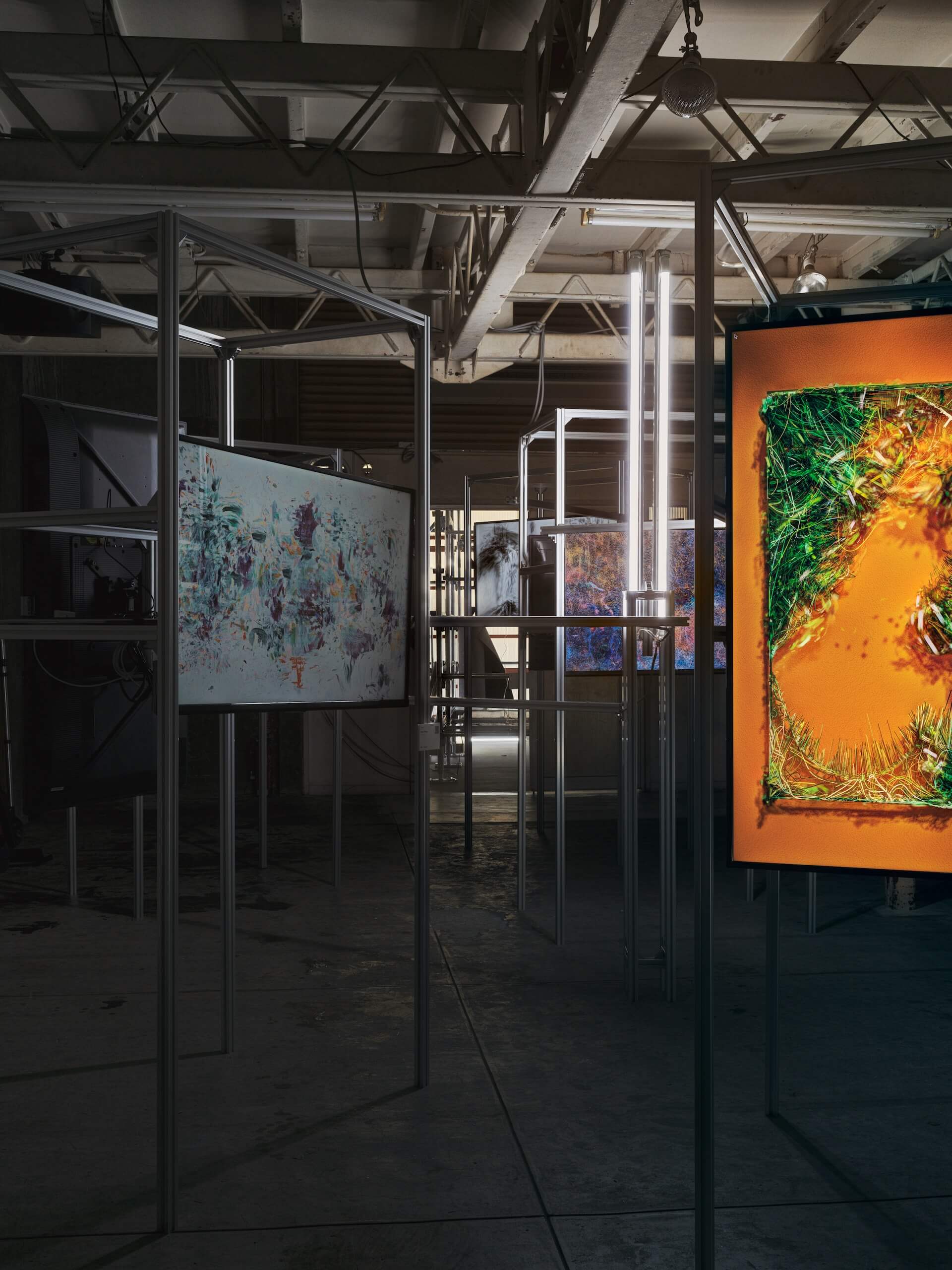 台韓藝術家展區，可見金屬支架作為展陳螢幕的支撐結構，以及周圍擺置的日光燈管。（dialog()東京團隊提供）