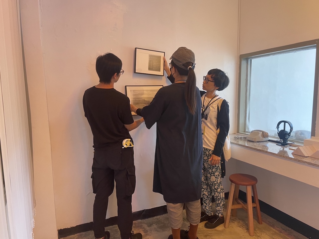 蔡明君與展覽技術人員和藝術家於「2023年綠島人權藝術季」展場綠洲山莊會客室討論作品裝置。（蔡明君提供，攝影／蔡美娟）