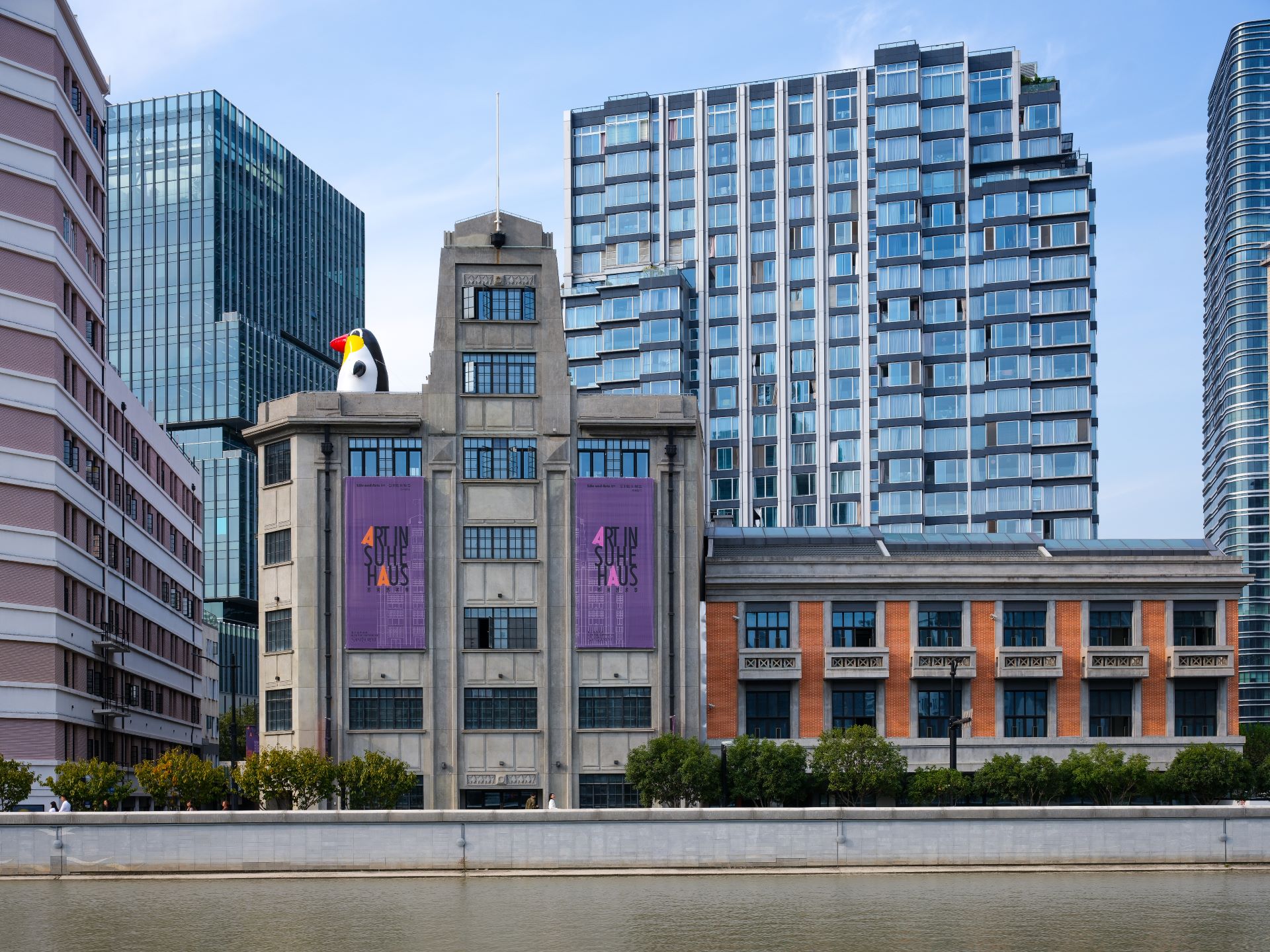 位於上海新的藝術機構聚集地蘇河灣的蘇河皓司外景，屋頂的藝術裝置為藝術市場炙手可熱的女性藝術家孫一鈿的作品《熱帶企鵝》。（圖片由Suhe Haus蘇河皓司提供）