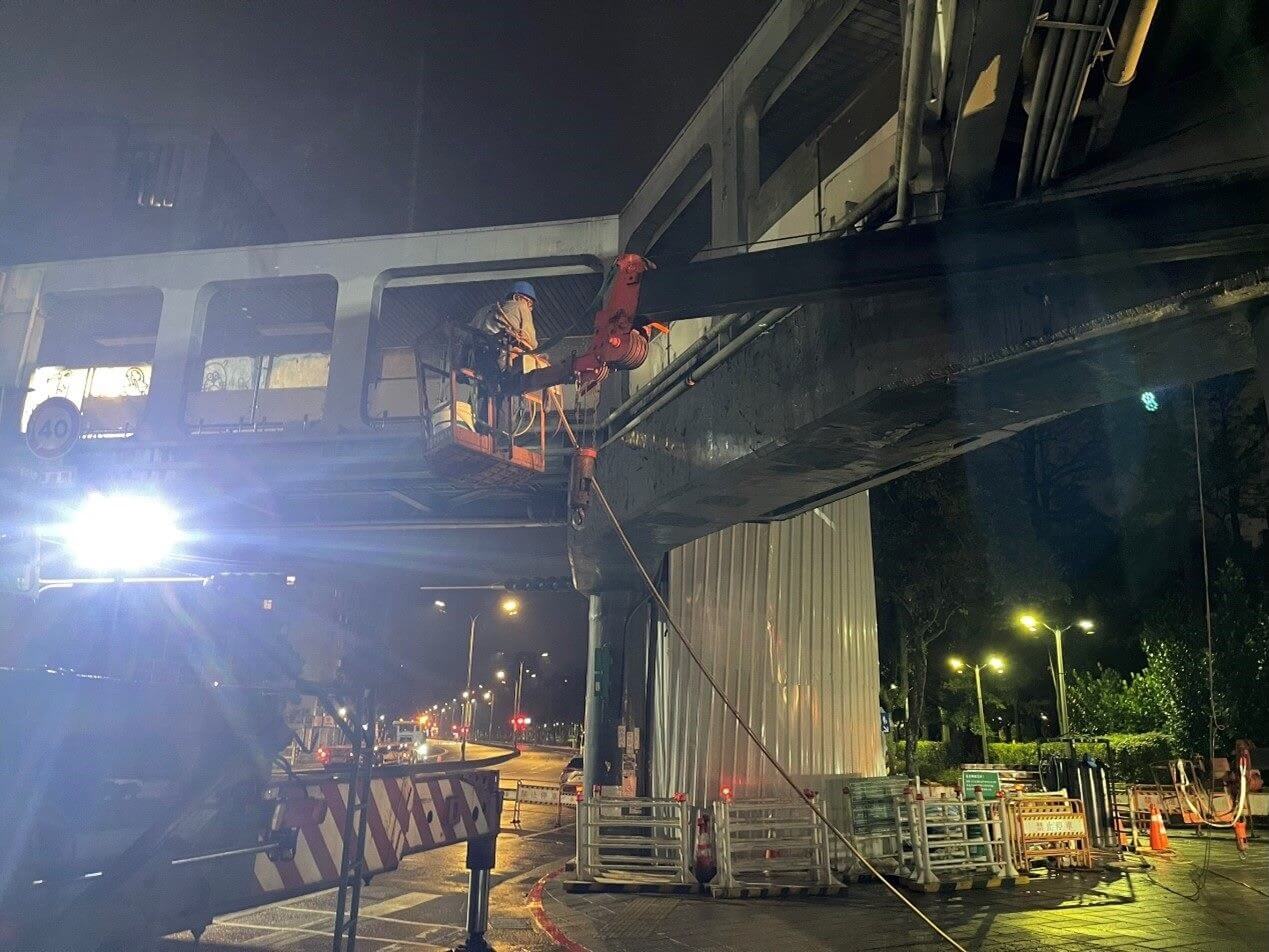 新工處於11月22日新聞稿，針對天橋拆除施工承攬廠商職業安全措施事宜說明：廠商拆橋進行高空作業時業依規定設置防墜措施，為慎重起見，再搭配全身背覆式安全帶勾掛安全母索，發揮雙重防護功效。圖為作業人員穿戴全身背覆式安全帶。（圖片取自臺北市政府工…