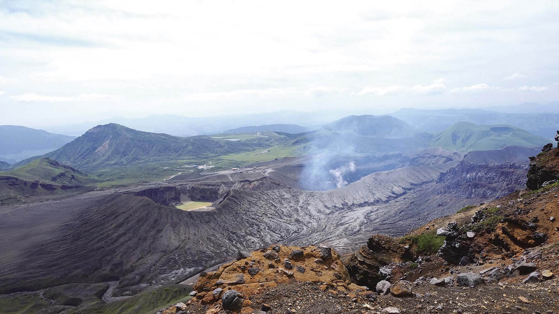 短居阿蘇市期間，鄭琬融從中岳山上望去的景色，是新的火山口正冒著煙，而一旁的第二火口早已冷卻。（鄭琬融提供）