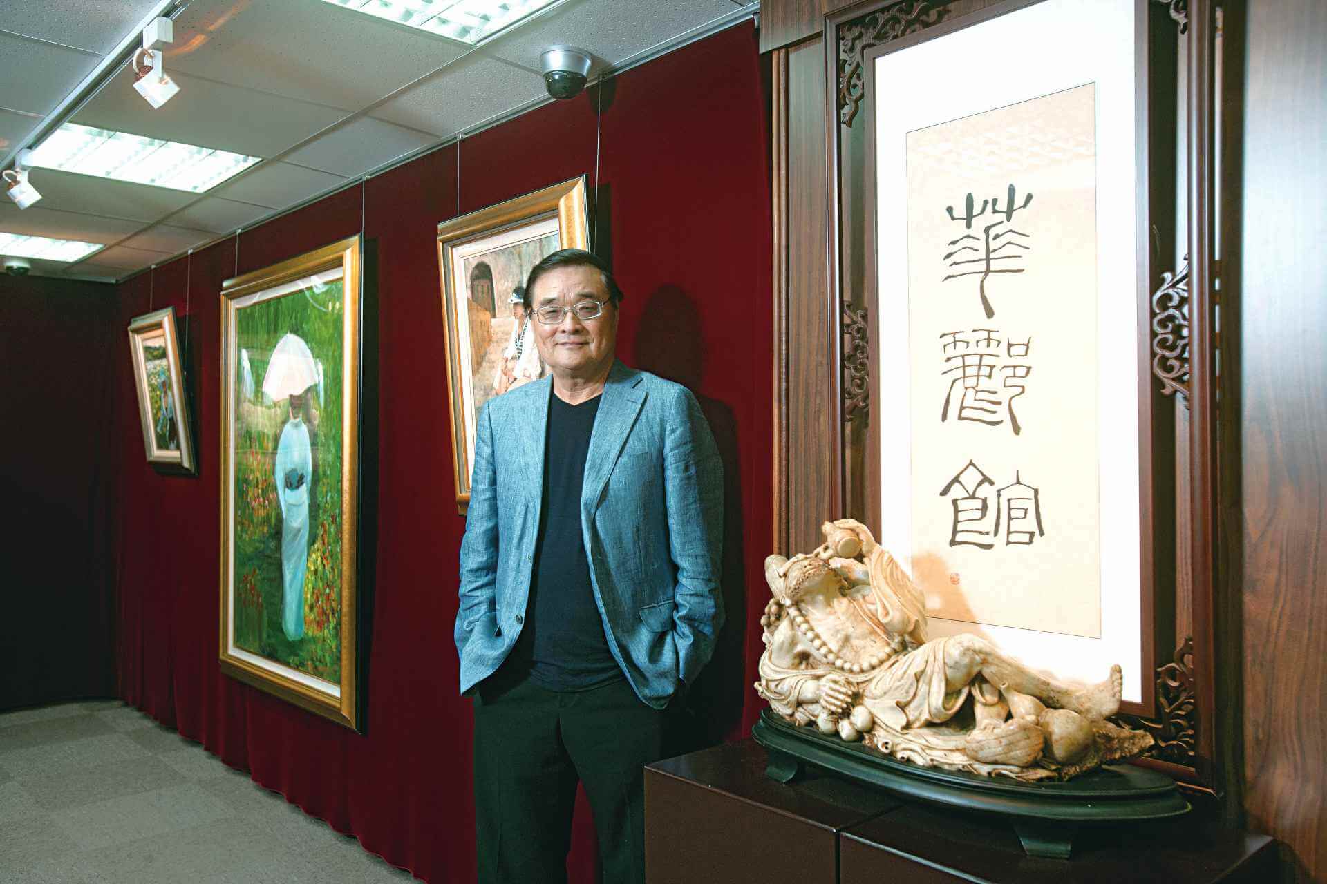 翫雅集理事長潘文華，他以夫妻倆人名字裡的「華」與「酈」，取堂號「華酈館」。華酈館三字為秦孝儀所題；潘文華身旁的油畫即為夫人所創作。（攝影／林煒凱，潘文華提供））