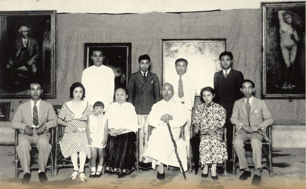 1933年，旅法畫家顏水龍（後排左二）在臺中舉辦留歐作品展覽會，展出部分臨摹自羅浮宮名畫的作品（如牆上右一的安格爾《泉》），林獻堂（前排右三）前往參觀並合影。（Public domain）
