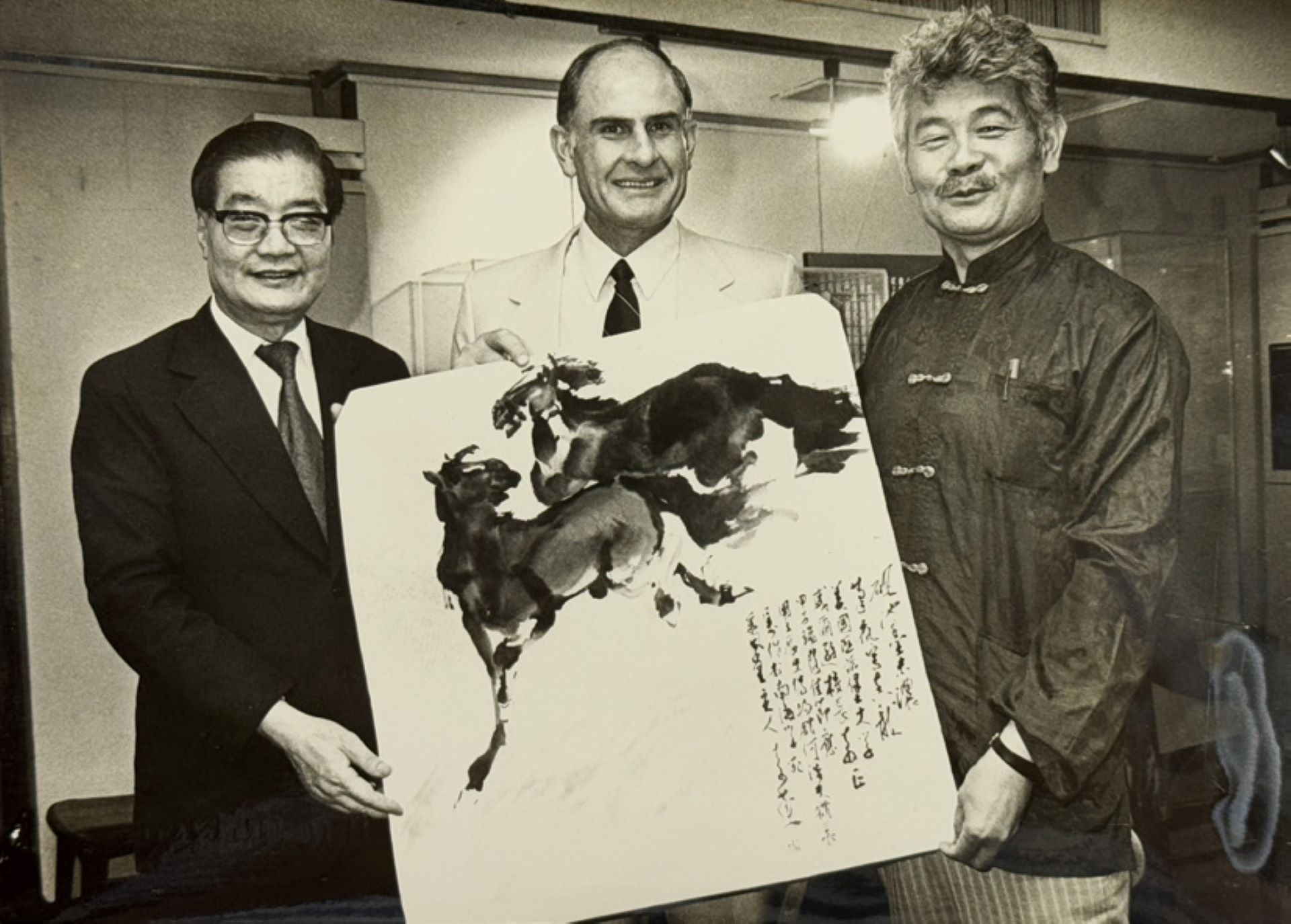 1984 年李奇茂（右）作《雙馬圖》贈美國匹茲堡大學校長威爾遜（中），左為史博館時任館長何浩天。