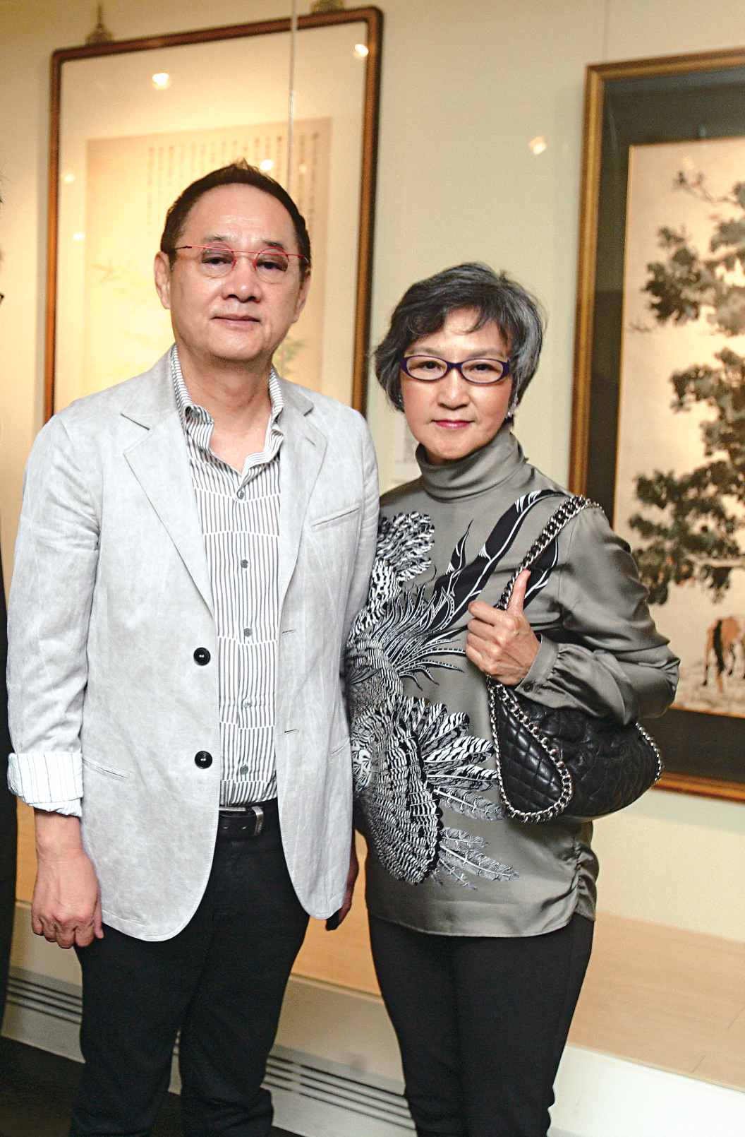 清翫雅集會員周義雄夫婦於書畫展場前合影。（攝影／陳永錚）