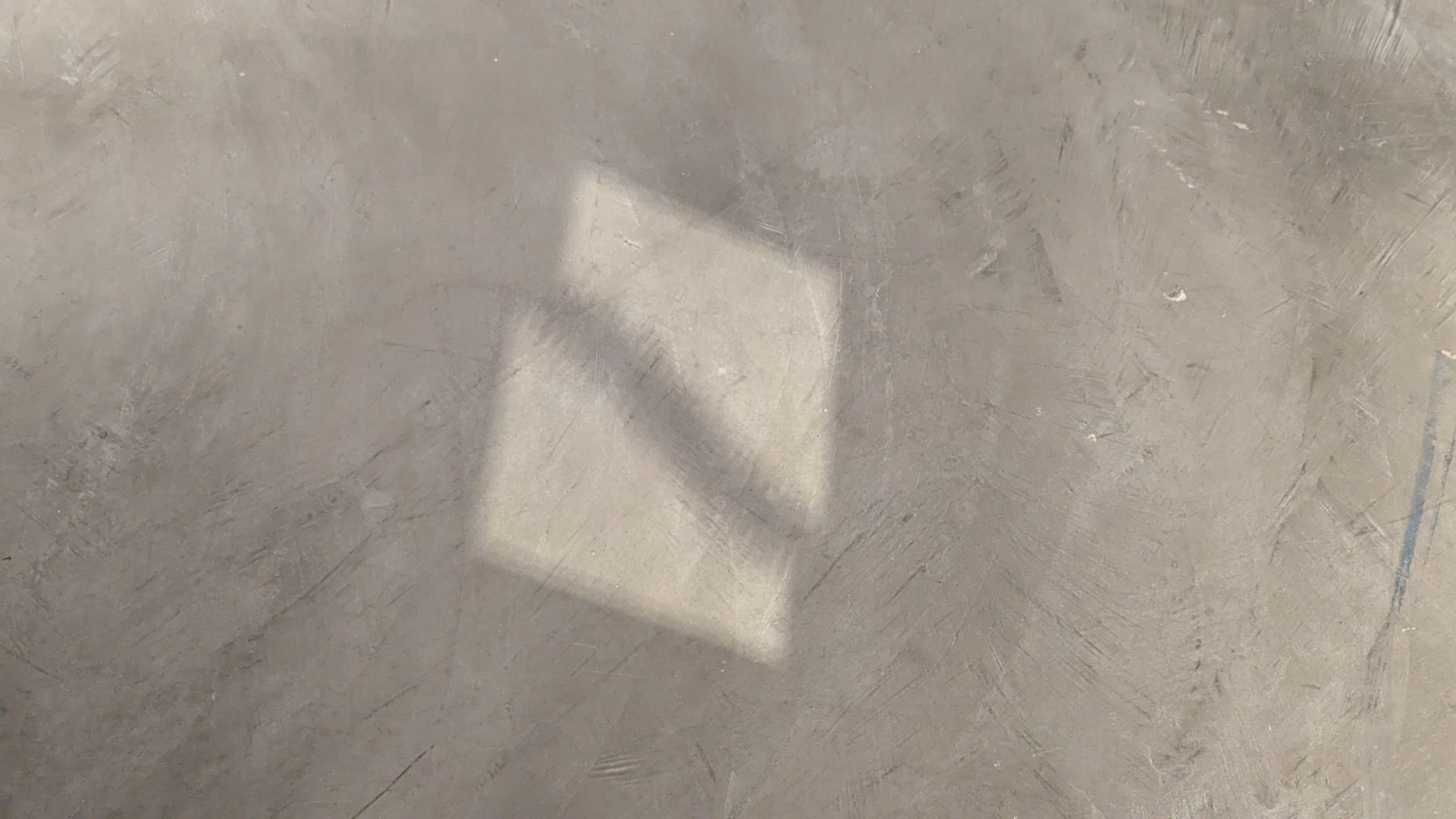 《修復的破碎鏡子》(Repaired Broken Mirror, 2023)在展場地板上留下光亮的燦射。在這張照片可見鏡子中間傷痕修補的部分在光影下留下了魍魎的痕跡。(攝影/印卡)