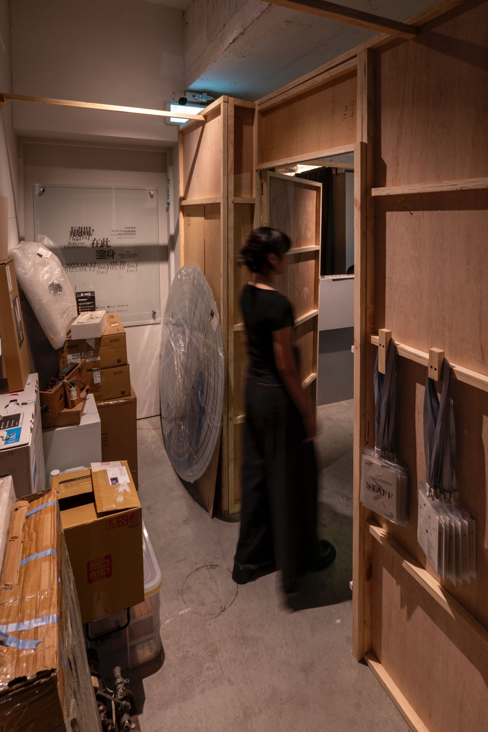 當觀眾走進《展間,在此側身》,首見繡有「staff only, but not only staff」的黑色門簾,在進入門簾後,則會見到堆積著各式器材、紙箱以及未展呈作品的《儲藏間》。圖為《儲藏間》。福利社提供