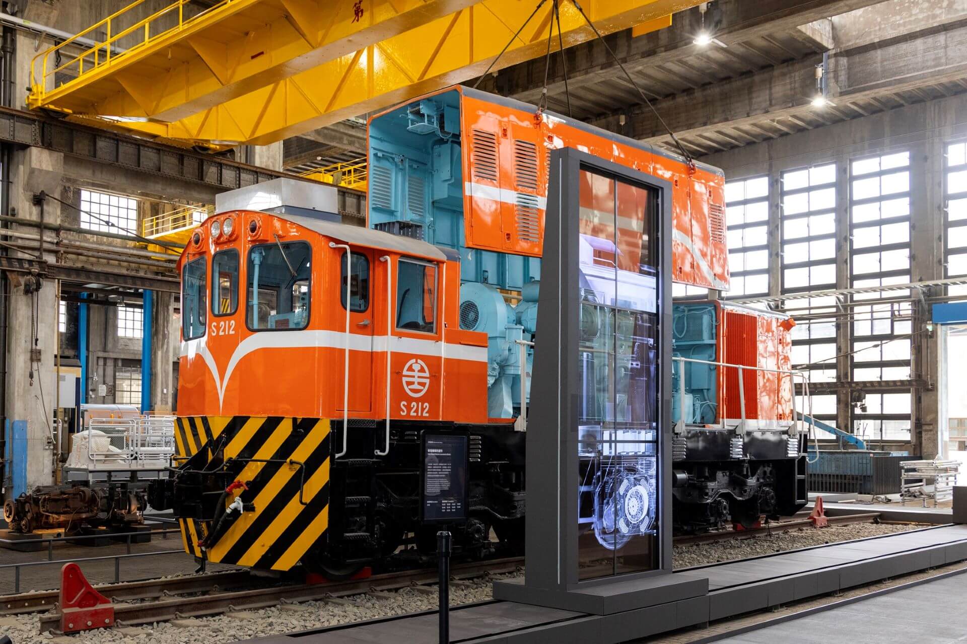常設展〈動力．火車 ── 柴電工場常設展〉懸掛透明車殼，柴電劇場「柴電機車的運作」，結合實體車輛及動畫，讓觀眾深入了解驅使S212柴電機車運行的引擎、主發電機、牽引馬達等內部構件，環環相扣的運轉原理。（國家鐵道博物館提供）