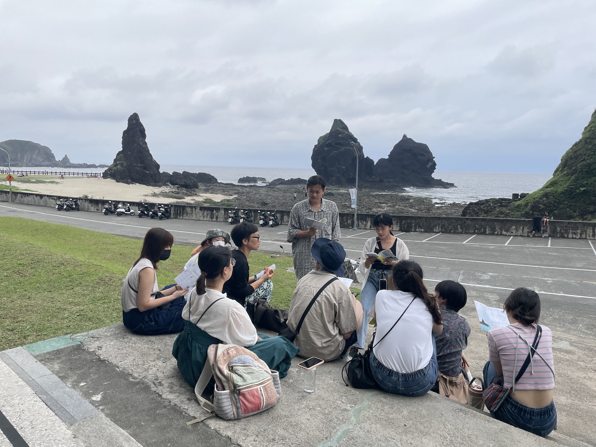 圖為蔡明君於2023年綠島人權藝術季期間，為臺東大學美術產業學系學生導覽展覽。她指出，美術系課程仍多以培養藝術創作者為主，與產業實務、管理或職涯發展相關的課程比例明顯不足，反映學院與業界之間長期存在的距離。（蔡明君提供）