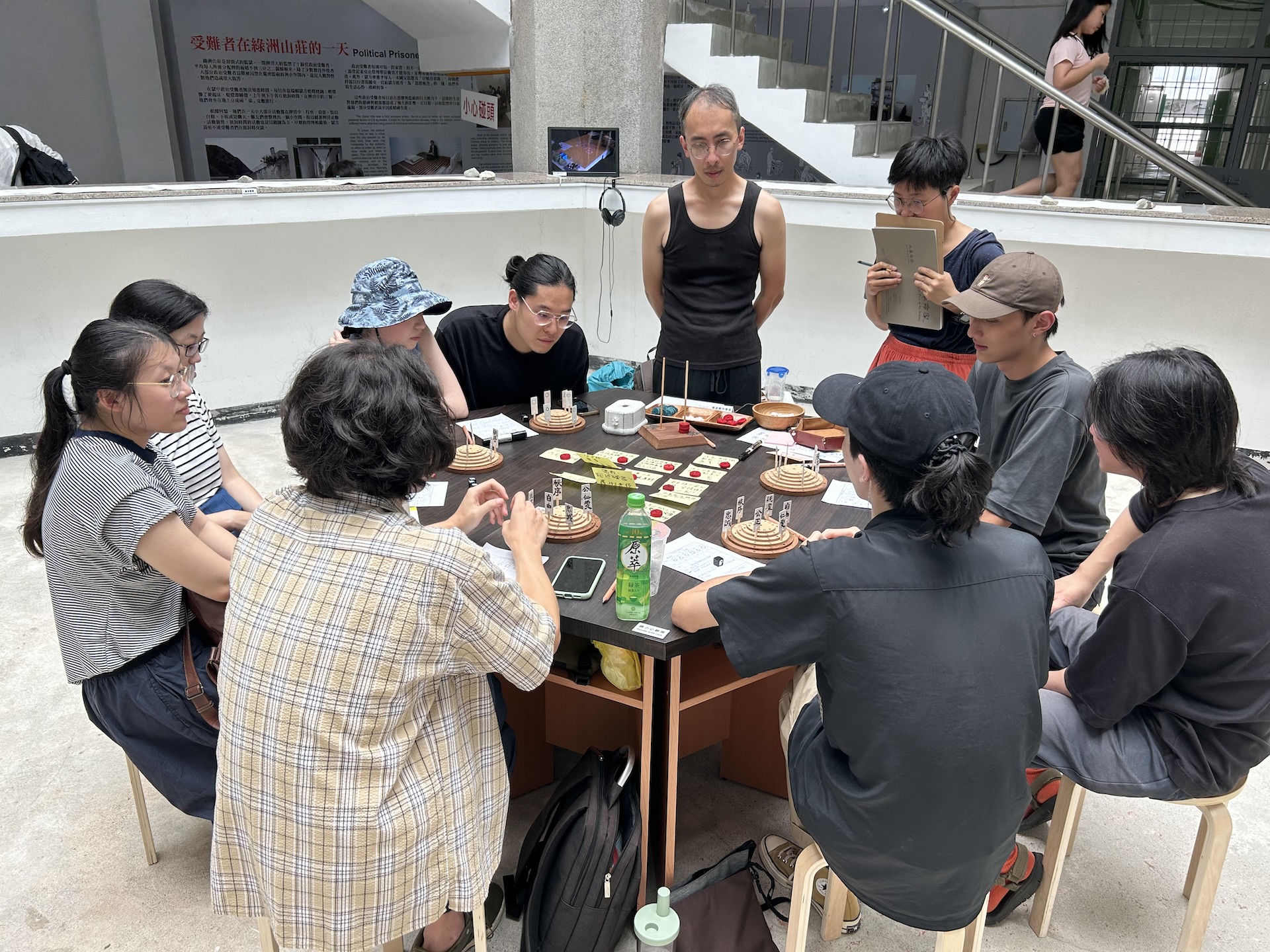圖為蔡明君於2023年綠島人權藝術季期間，帶領東海大學美術系學生透過桌遊進行導覽與學習。她強調，雖然實務經驗多半需在做中學，但透過課程的引導與累積，許多學生已逐步成為能獨立執行專案的藝術行政與技術人員。然而，行政與技術類課程在學院中仍常被視…