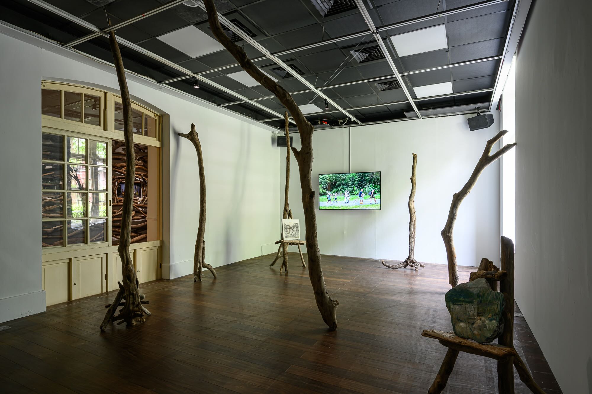 王煜松與「花蓮地震寫生團」的《沒有葉子的森林》，由21位藝術家攜帶炭筆與現地拾得的石塊、木枝等前往震區寫生。另外可以注意整體室內展間的天花版，均是裸露無遮蓋的設計。&nbsp;台北當代藝術館提供
