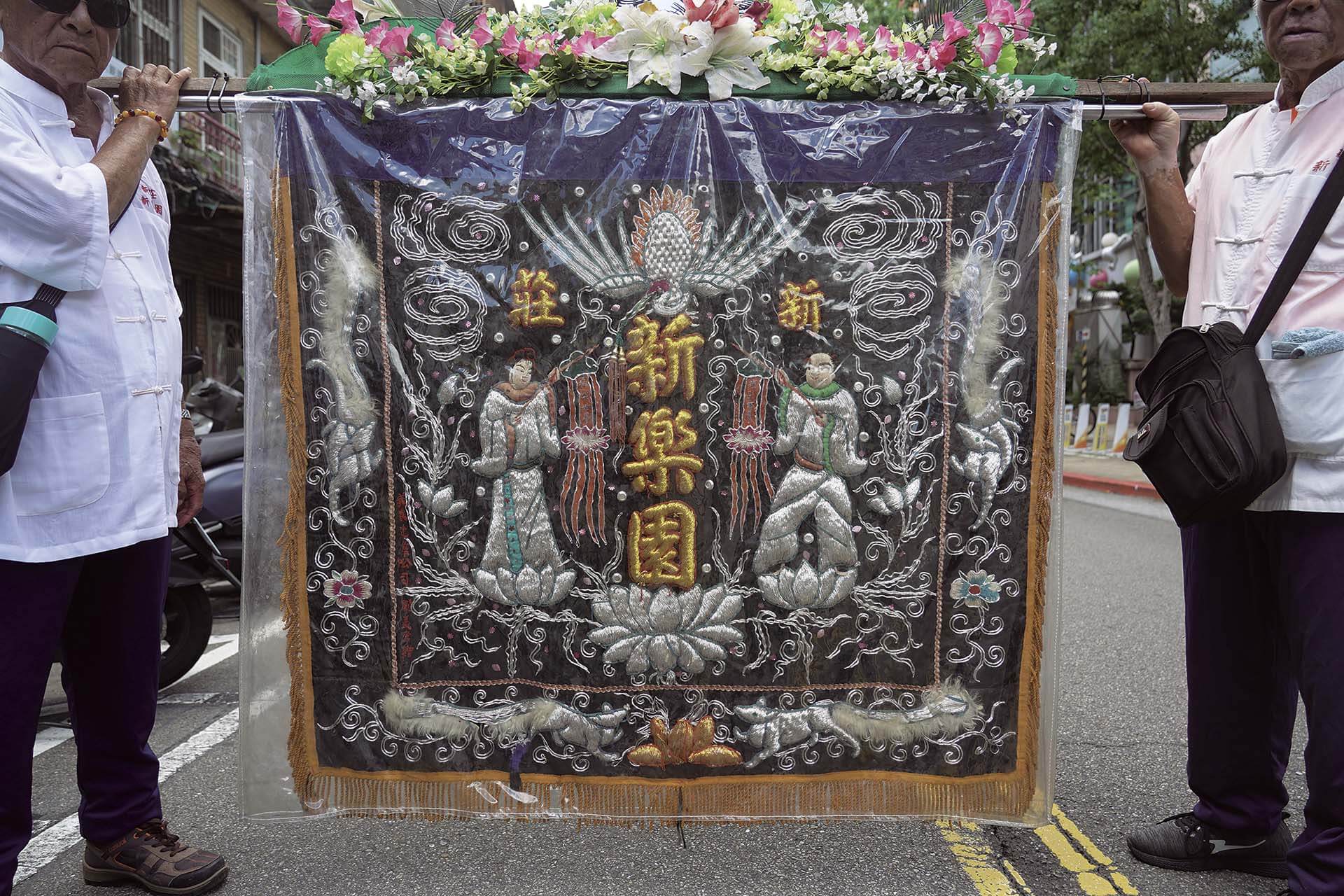 北管喪事陣頭的旗幟有刺繡金童玉女。攝影／張靖委。