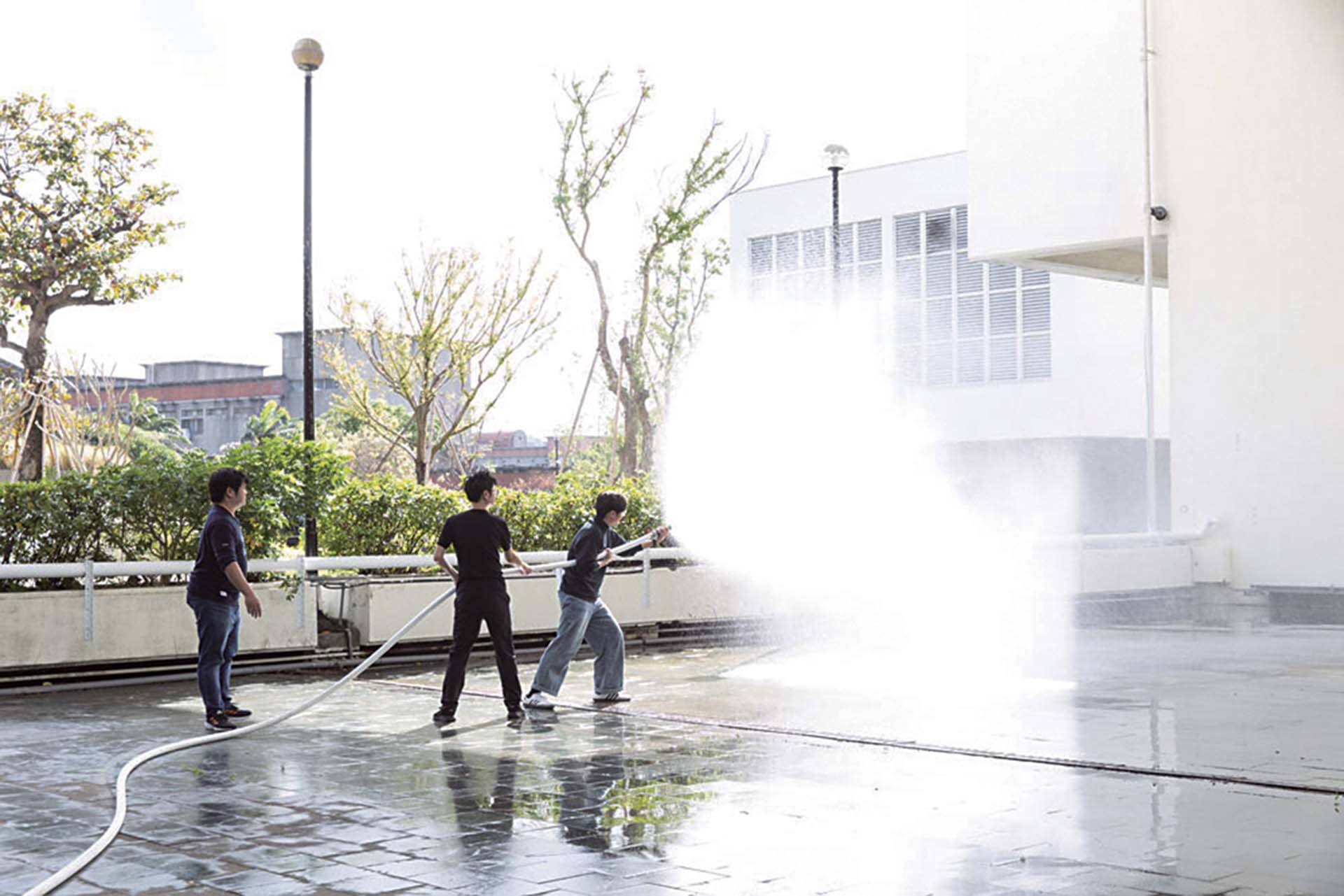 北美館人員於消防演習實際操作消防水帶。（臺北市立美術館提供）