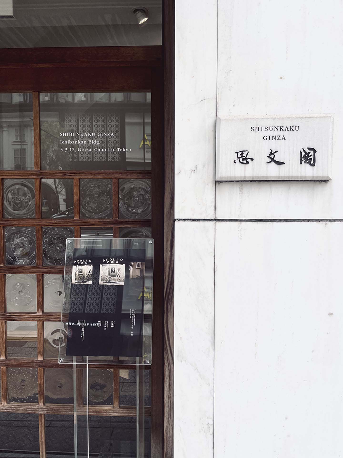開幕當日，「多孔的檔案．探照」展覽海報放在思文閣門口，形成「櫥窗照後方是可進入的玻璃門」這樣的穿透性。（攝影／葉杏柔）