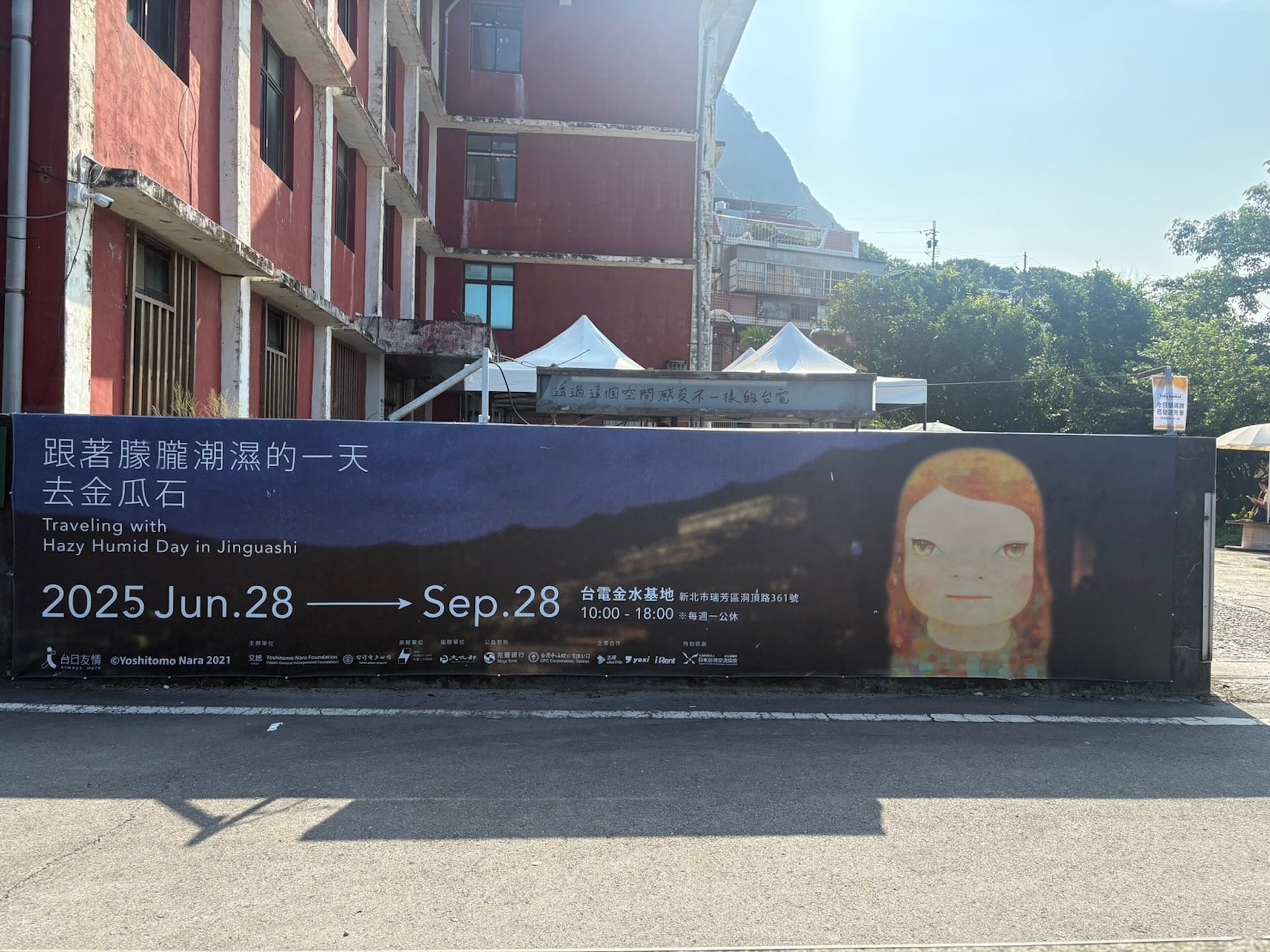 圖為「跟著朦朧潮濕的一天去旅行」於台電金水基地外的視覺橫幅。（攝影／李靜）