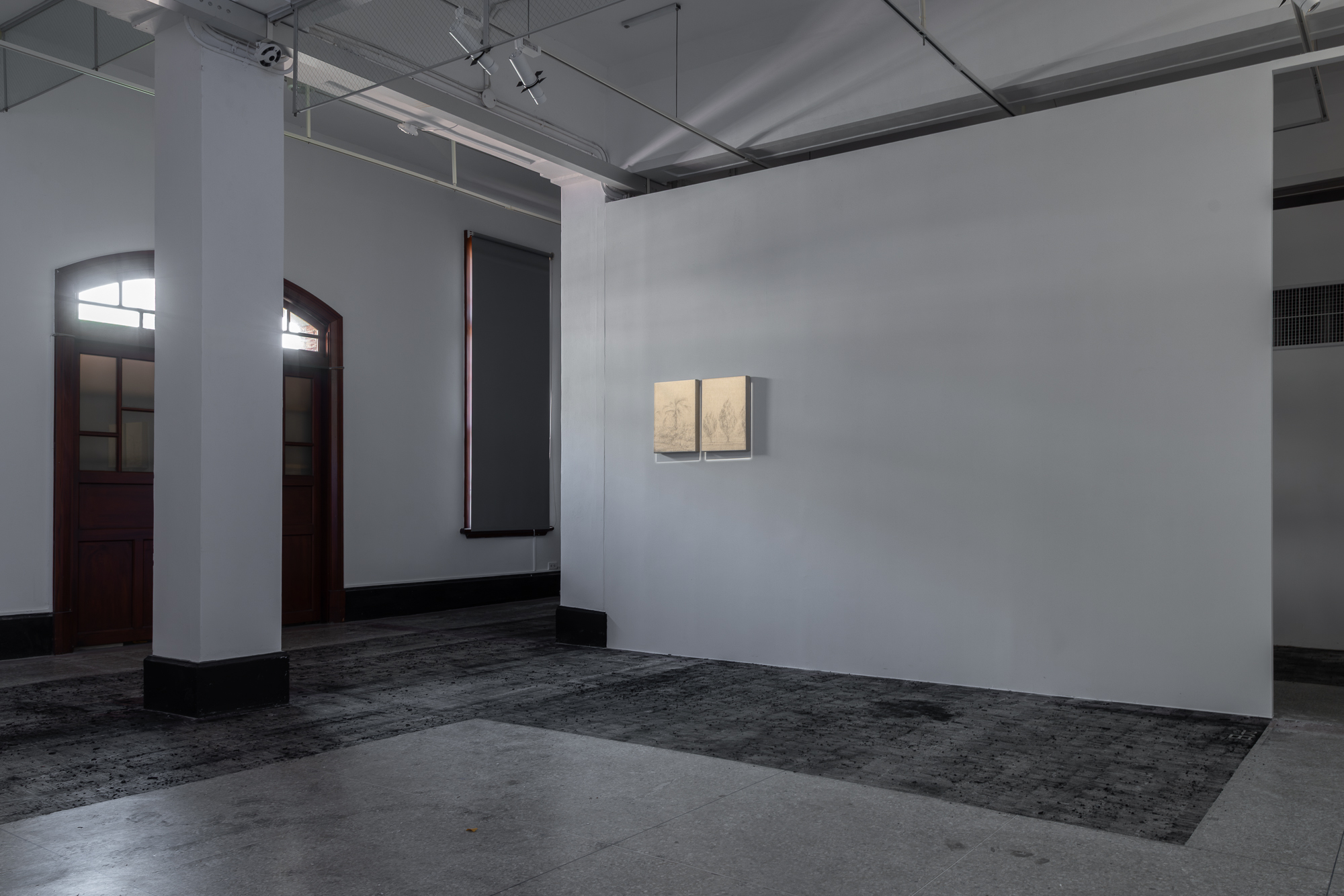 彭韋,《鋪上一層灰》,炭筆,尺寸依空間而定,2025。牆面作品為《拂風》,鉛筆、棉麻纖維,33 × 45.5 cm,2023。(攝影/王士源)