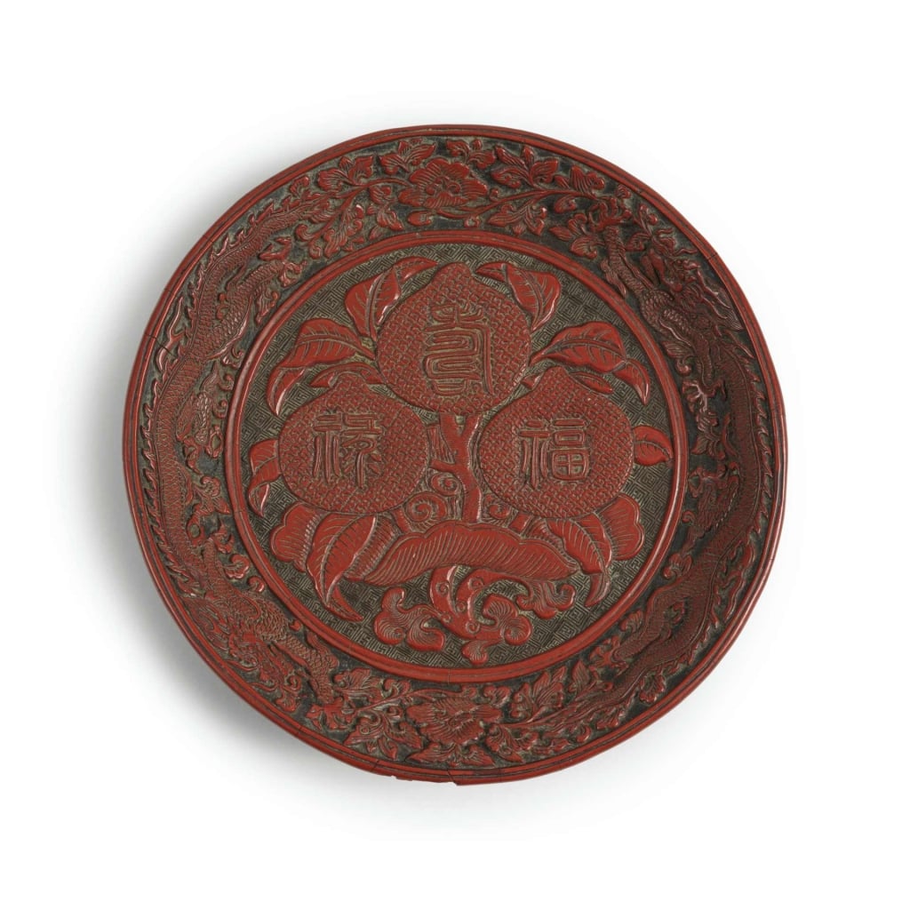 明嘉靖《剔紅福祿壽三桃紋圓盤》，「大明嘉靖年製」款，徑19公分，估價3萬至5萬歐元。