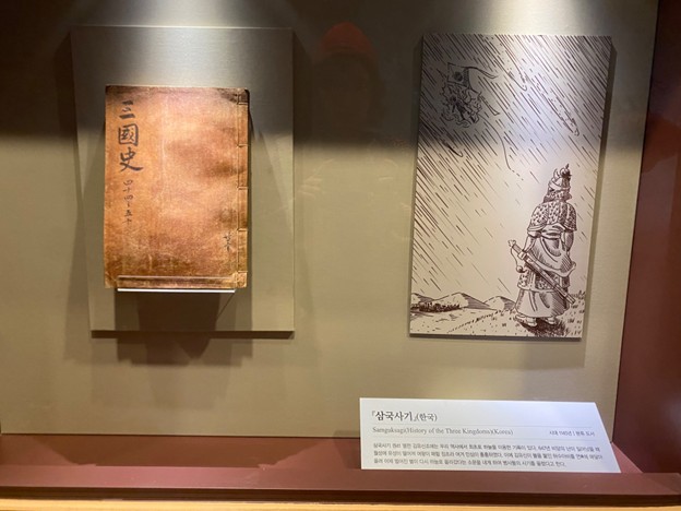 相｜《三國史》是一本仿寫《史記》筆法的史書。跟參觀者講金庾信、鄭平九，以及《西漢演義》四面楚歌中的故事（「在楚軍與漢軍的最後一場戰役中，楚軍被漢軍包圍、苦戰之際，劉邦的謀士韓信製作了用牛皮做成的大風箏，讓弓箭手乘風箏攻擊，或讓擅長吹笛的人乘…