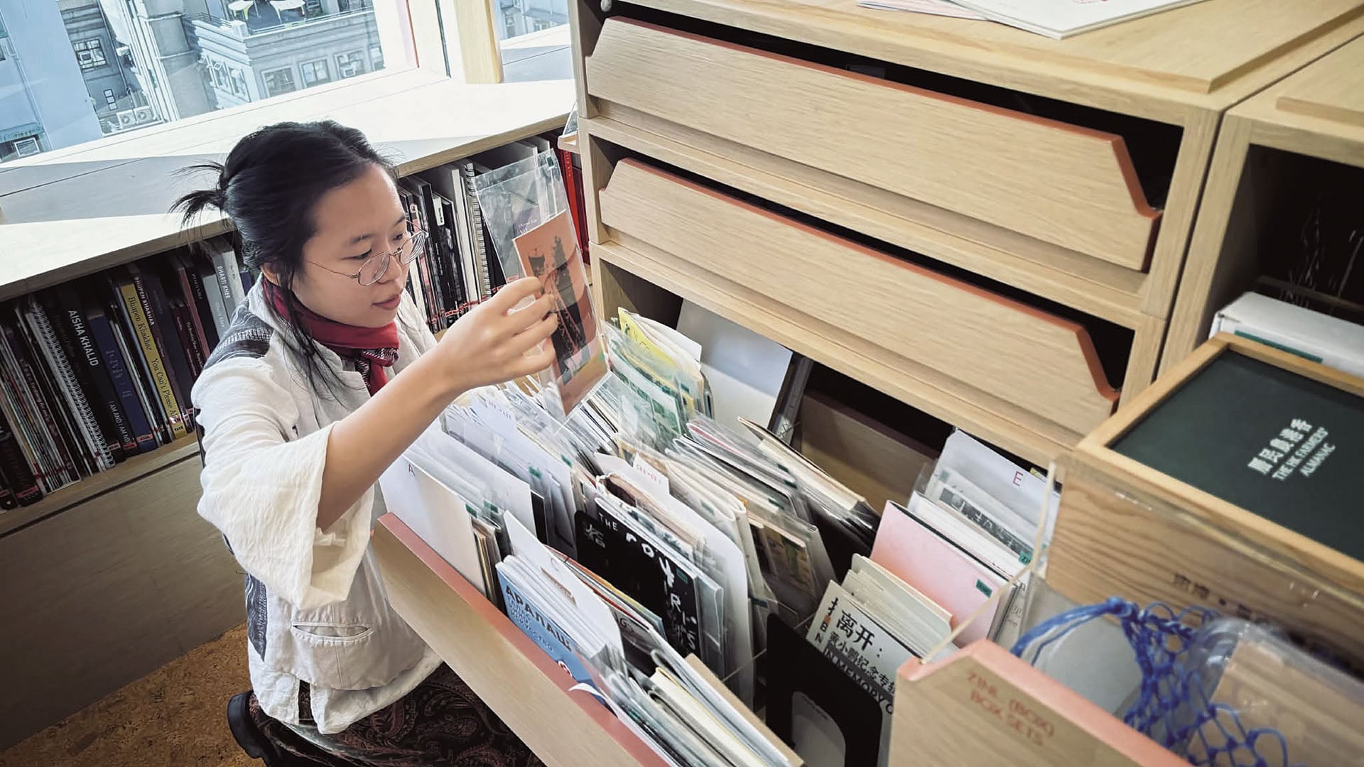圖為香港 AAA 現任小誌館藏負責人周亦瑤。她將小誌比喻為圖書館的「粒線體」，在穩定的典藏系統中提供微弱卻必要的能量，使文獻庫保持流動與「活著」，也映照香港近年小誌出版的活性與生命力。（圖片由汪怡君提供）