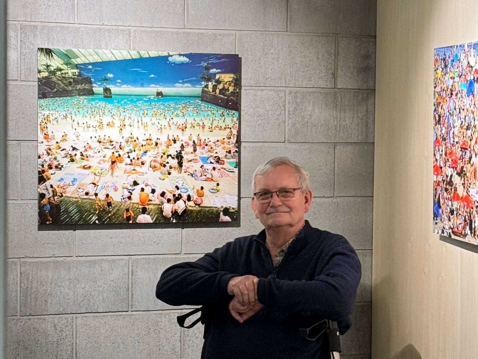 圖為馬丁・帕爾於2025年4月京都國際攝影節（KYOTOGRAPHIE）與其作品《Japan, Miyazaki, The Ocean Dome, 1996》合影。（攝影／李京樺）
