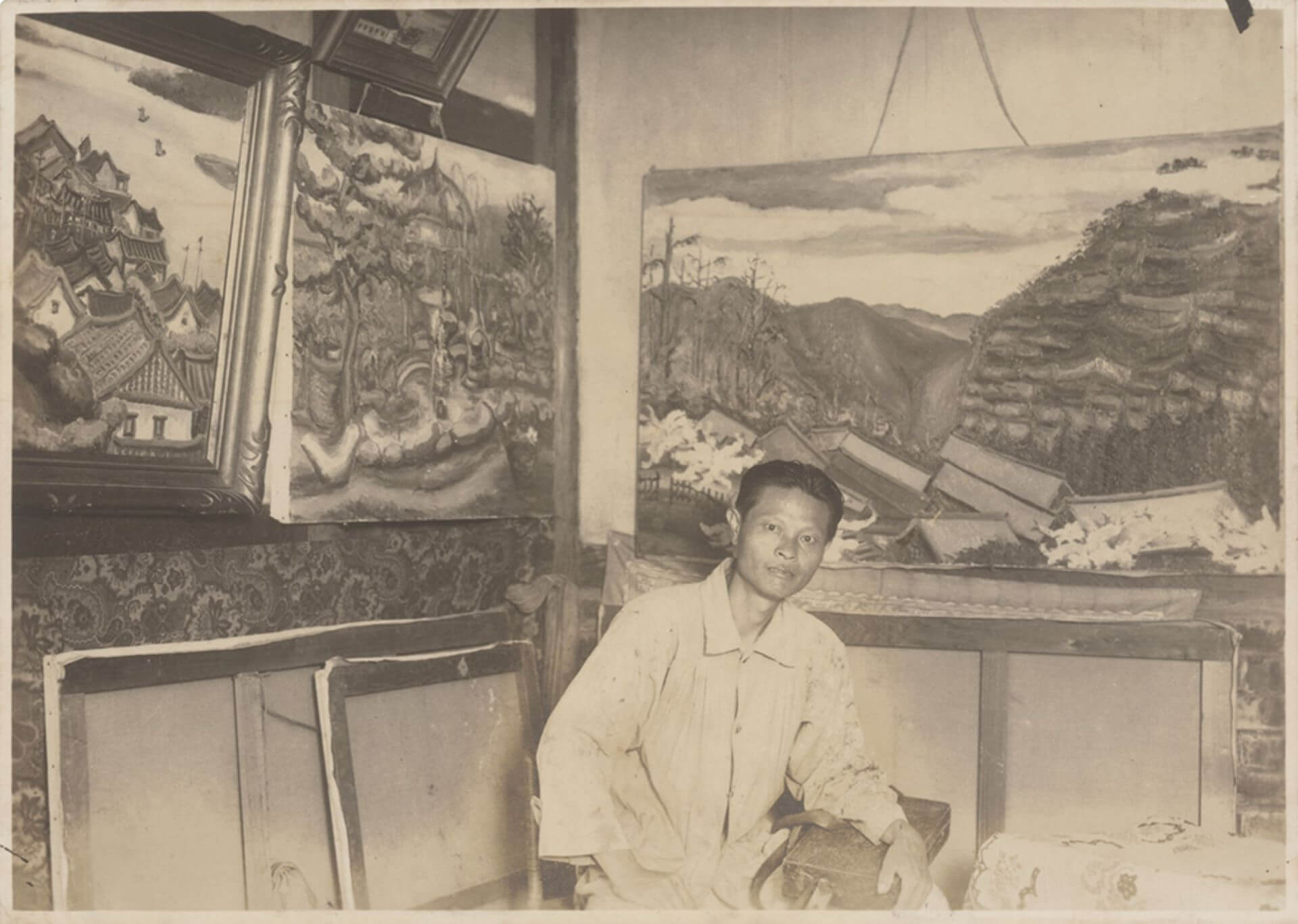 1935年秋，陳澄波在自宅與畫作合影，牆上由左至右分別是〈淡江風景〉、〈琳瑯山閣〉與〈阿里山之春〉。（陳澄波文化基金會網站）