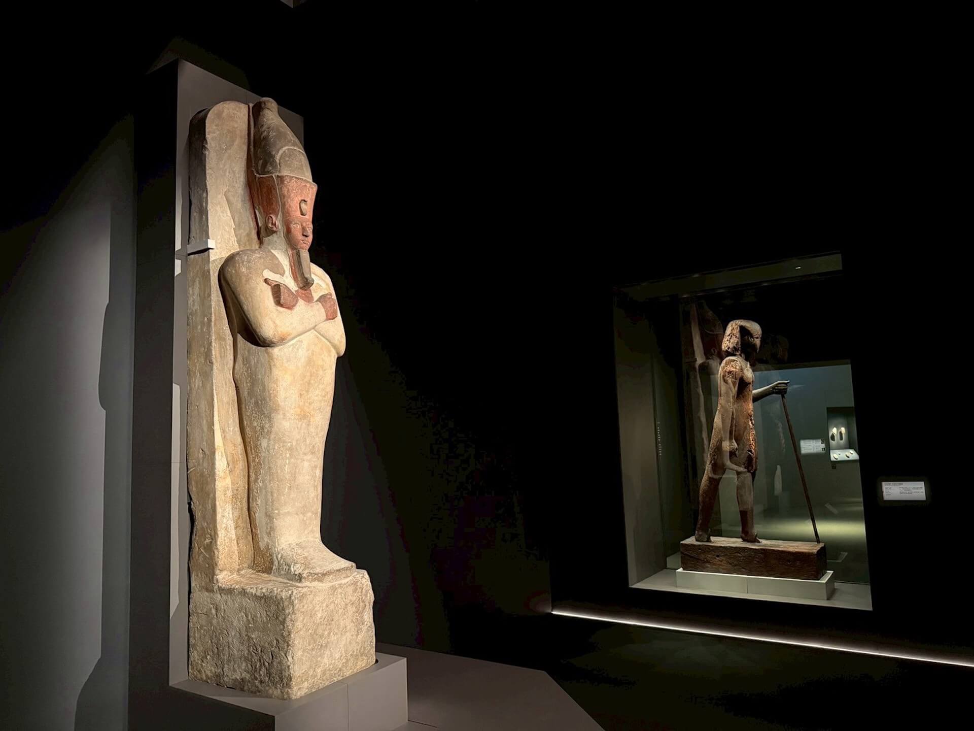 這尊雕像將阿蒙霍特普一世塑造成冥王歐西里斯 (Osiris) 的形象，捲曲鬍鬚顯示其神聖身分，而歐西里斯般的造型，象徵法老將如同冥界之主般獲得永生。（攝影／朱佑霖）