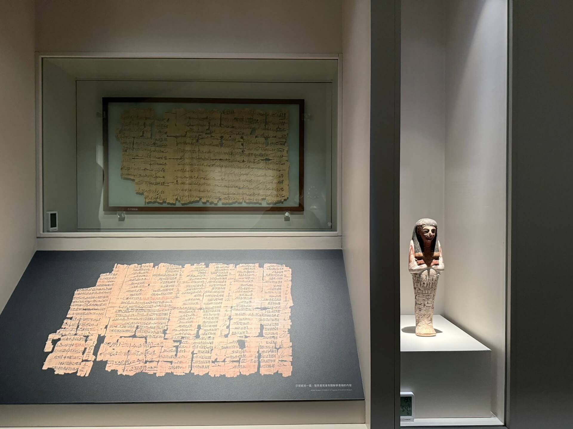 書吏奎恩赫爾克佩謝夫（右側是他的紗布提俑）以獨特的潦草筆跡聞名。這件不完整的莎草紙兩面都有書寫，一面是他抄錄了史上有名的卡疊石戰役，有關拉美西斯二世與西臺人之間的衝突。背面則是另一位書吏抄錄解夢書籍的工整文字。這件是本次專案策展人最喜愛的文…