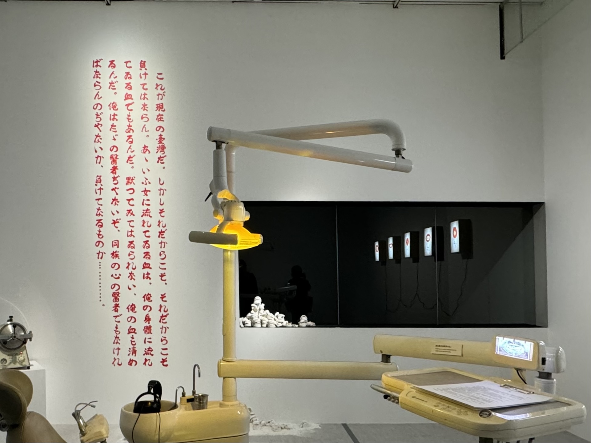 「這就是現在的臺灣。但正因如此、正因如此才不能認輸。那種女人身上所流的血，也在我的身體裡流淌著。可不能坐視不管，我的血也得要清潔才行。我可不只是醫者，還得當同族的心之醫者不是嗎？怎麼可以認輸⋯⋯。」牆上以日文摘錄周金波，其單篇小說〈水癌〉中…