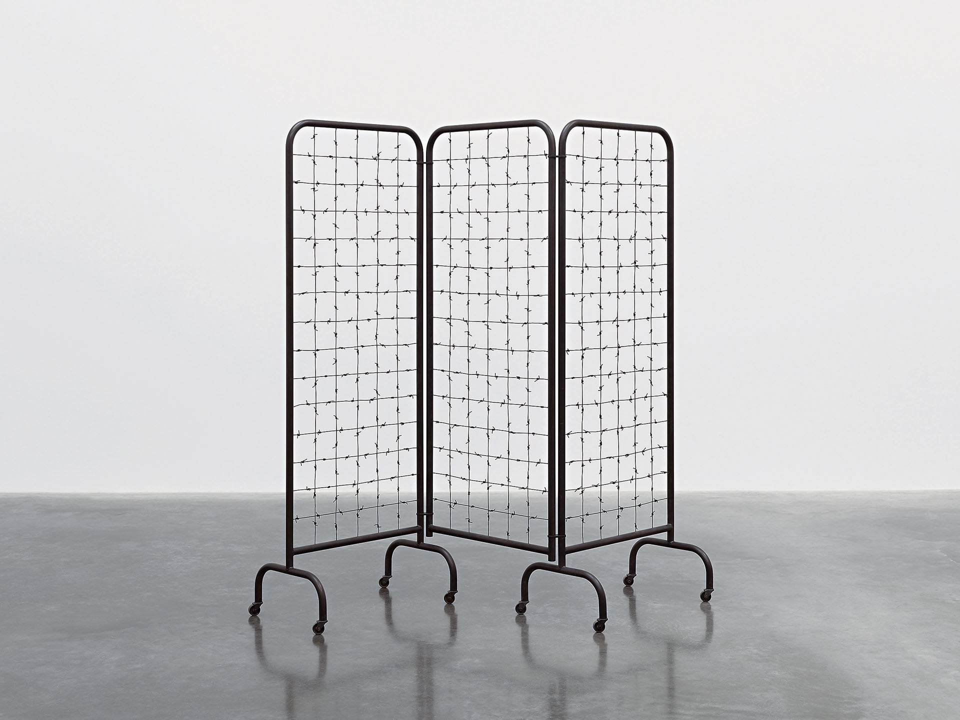 莫娜.哈透姆|Divide Three panel steel screen and barbed wire 67 11/16×74×18 7/8 in. (172×188×48 cm) 2025 © Mona Hatoum. Photo…