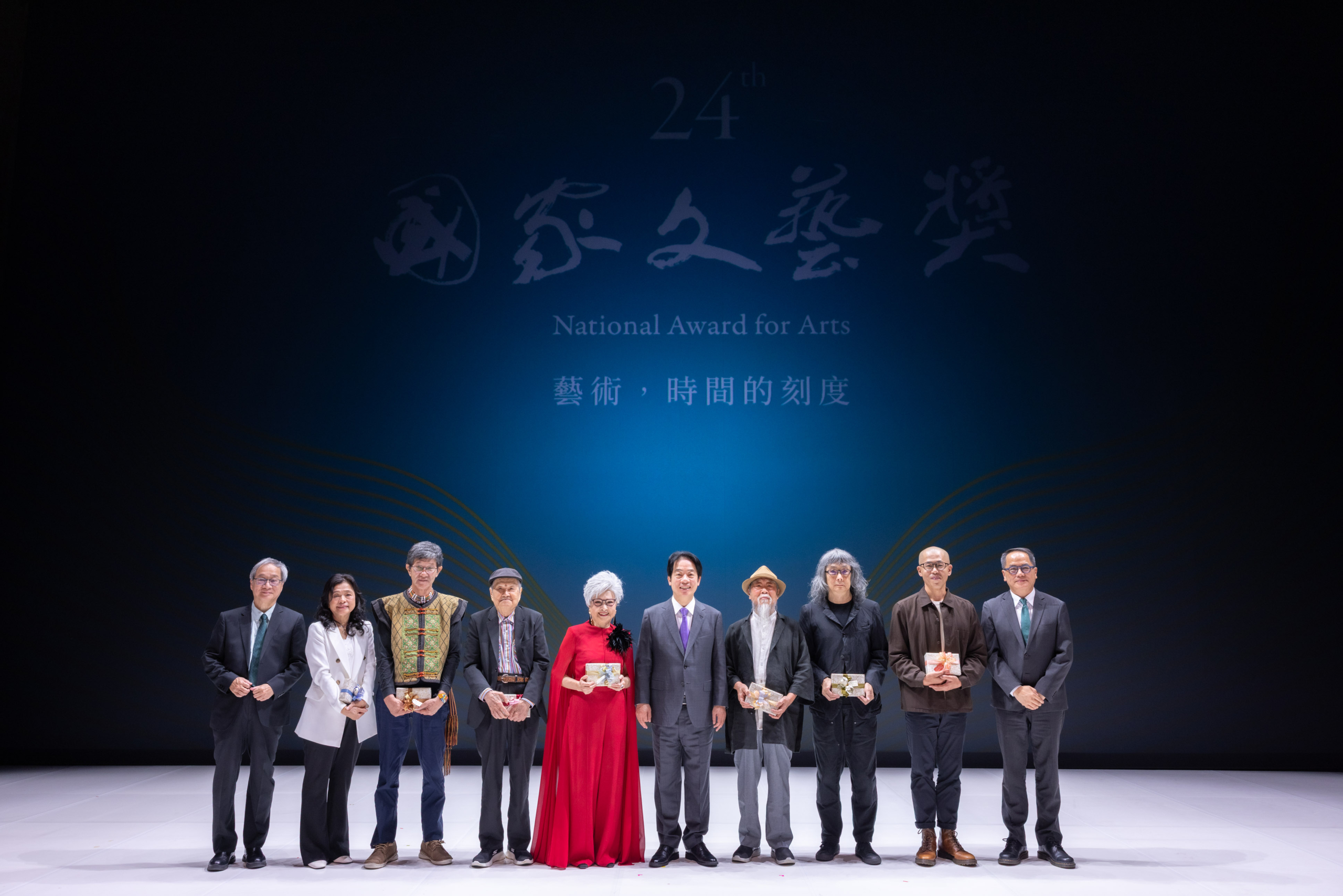 第24屆「國家文藝獎」贈獎典禮現場，左起：文化部部長李遠、吳春美（吳明益姊姊代為出席）、虞戡平、盧亮輝、王金櫻、總統賴清德、李再鈐、簡學義、林文中、國藝會董事長彭俊亨。（攝影／周嘉慧）