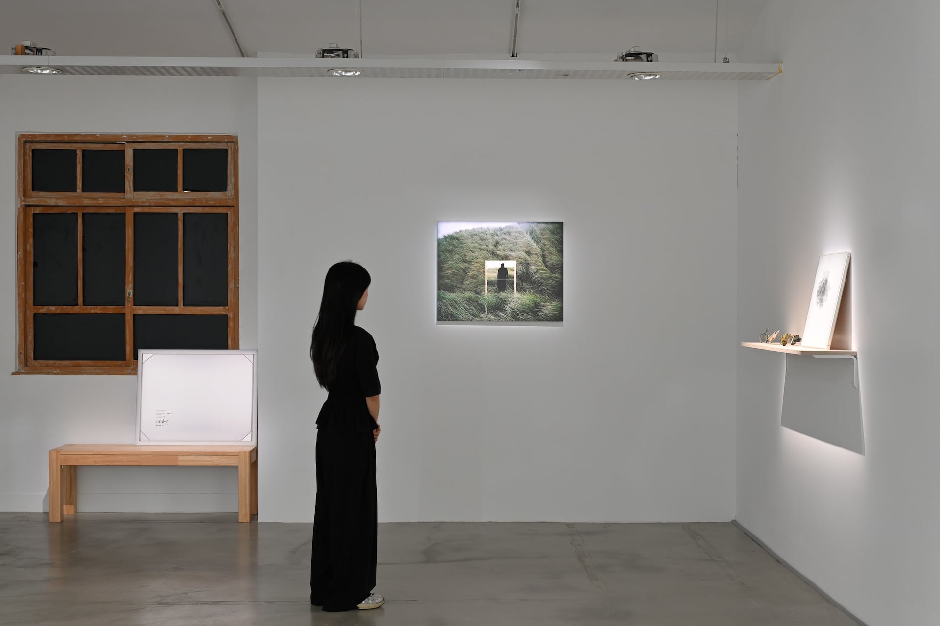掛在牆上的是Guillaume AMAT的《Open Field #01》，而在它左側長椅上的則是畫作的背面攝影，再攝影不只是更趣味性的拓展出空間性，更是在呈現關於平常觀眾看不到的「作品的檔案性」這件事。（攝影／吳承澤，有章藝術博物館提供）
