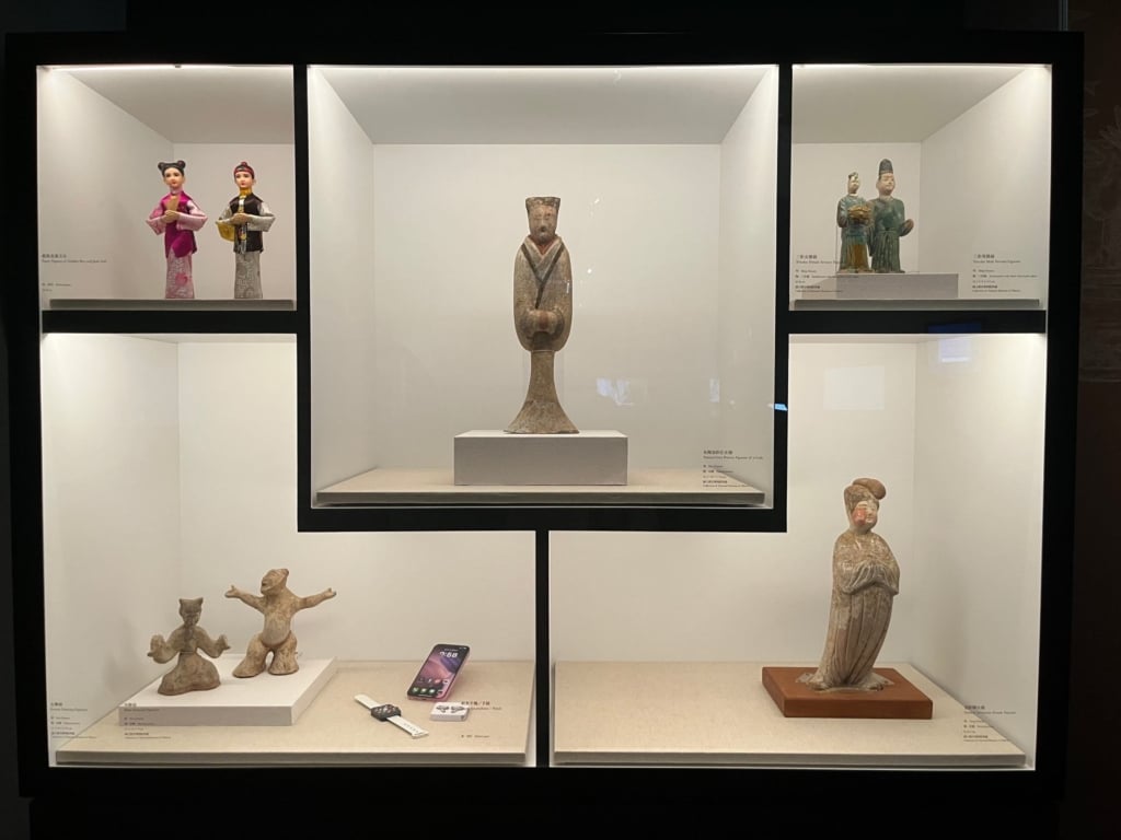 「終章未完：穿越生死的文化觀想」展出各式陶俑，其中作為娛樂的樂舞俑，今人更以紙紮手機提供娛樂功能。