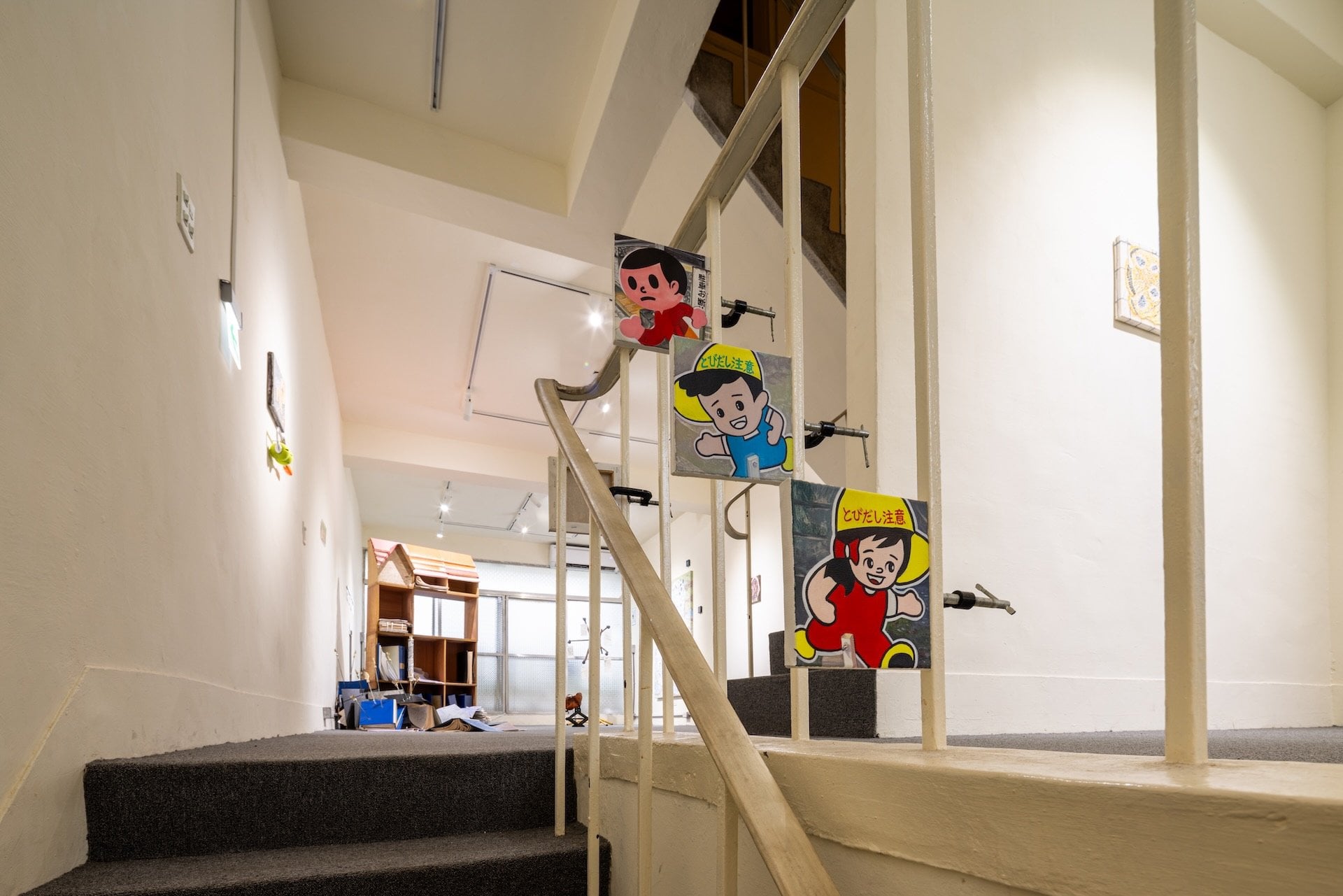 「Room In Room Out」展場一景，樓梯間以夾具展示林君晏於日本打工度假期間所繪製的招牌系列作品，沿著動線向三樓延伸，也與蕭其珩設置於展場外的招牌形成呼應。（謝以恭提供）