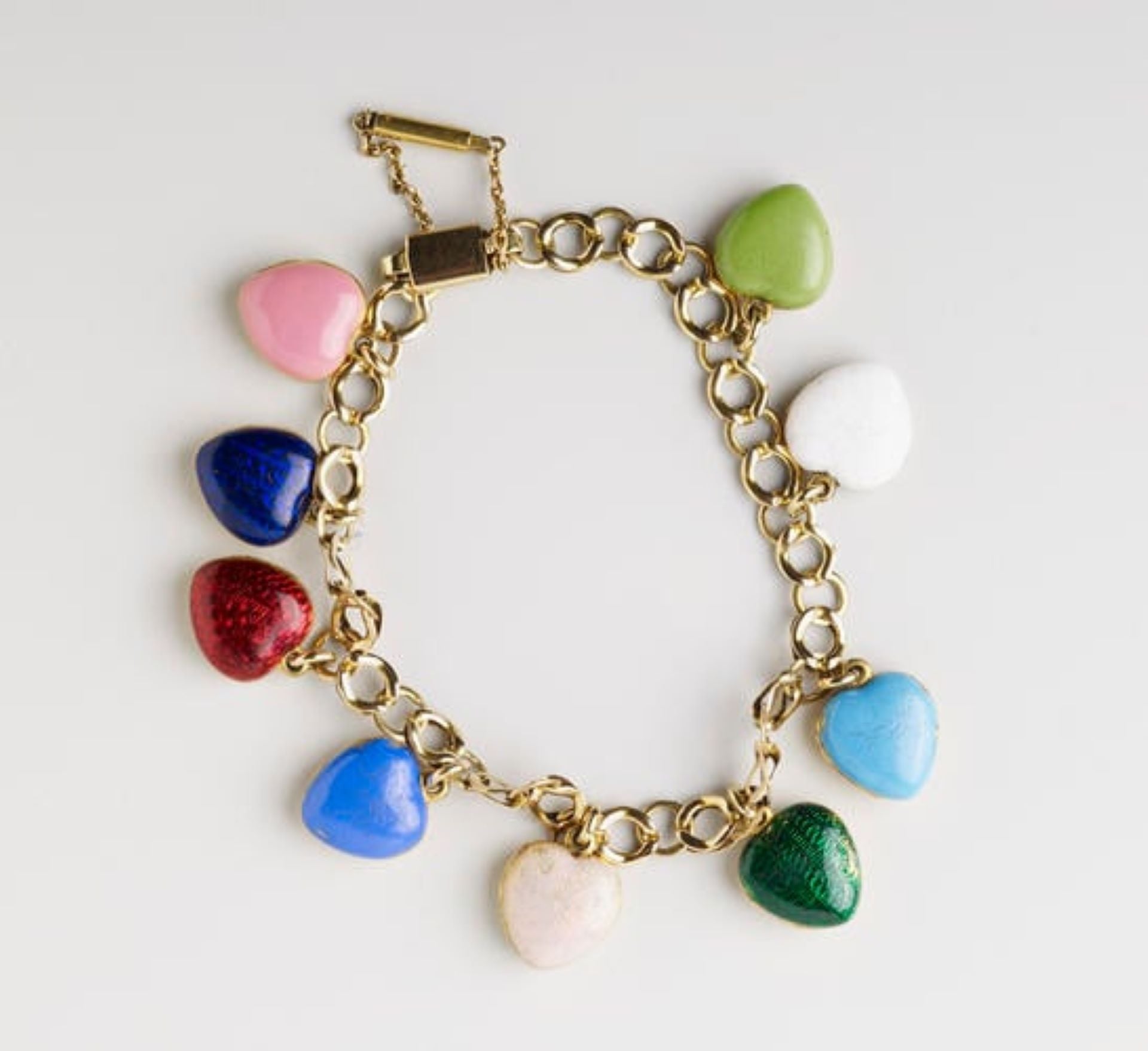 維多利亞女王的家庭手鍊(Bracelet),約1840年。金質鏈帶上掛有九枚不同顏色的琺瑯心形吊墜,內部保存維多利亞女王子女的髮絲。 (現藏於Royal Collection Trust)