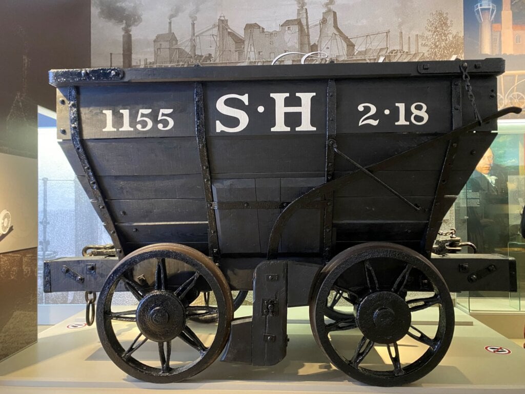 相｜這是一輛1829年的煤車。它是目前英國以外的歐洲地區所保存最古老的鐵路車輛。我們可以看到礦車的輪子是鋼鐵製造的輪子，在當時是非常新型的車輛。而拉這些煤車的，多半是馬匹，還有機頭。你猜這樣一輛車，可以運多少東西呢？答案是2.5噸！（拍攝於…
