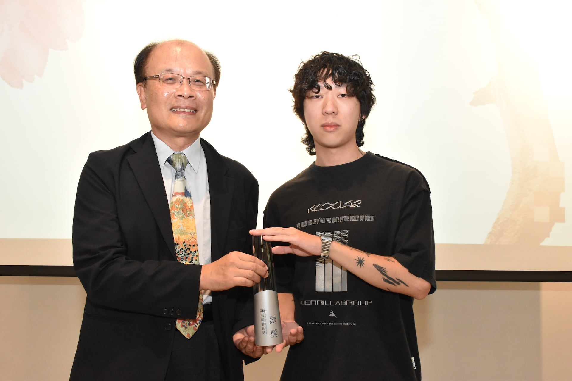 教育部終身教育司司長梁學政指出明維藝新獎的特殊之處，也正在於科技與藝術的相遇。圖為梁學政與銀獎得主陳岳宏合影。（明維教育基金會提供）