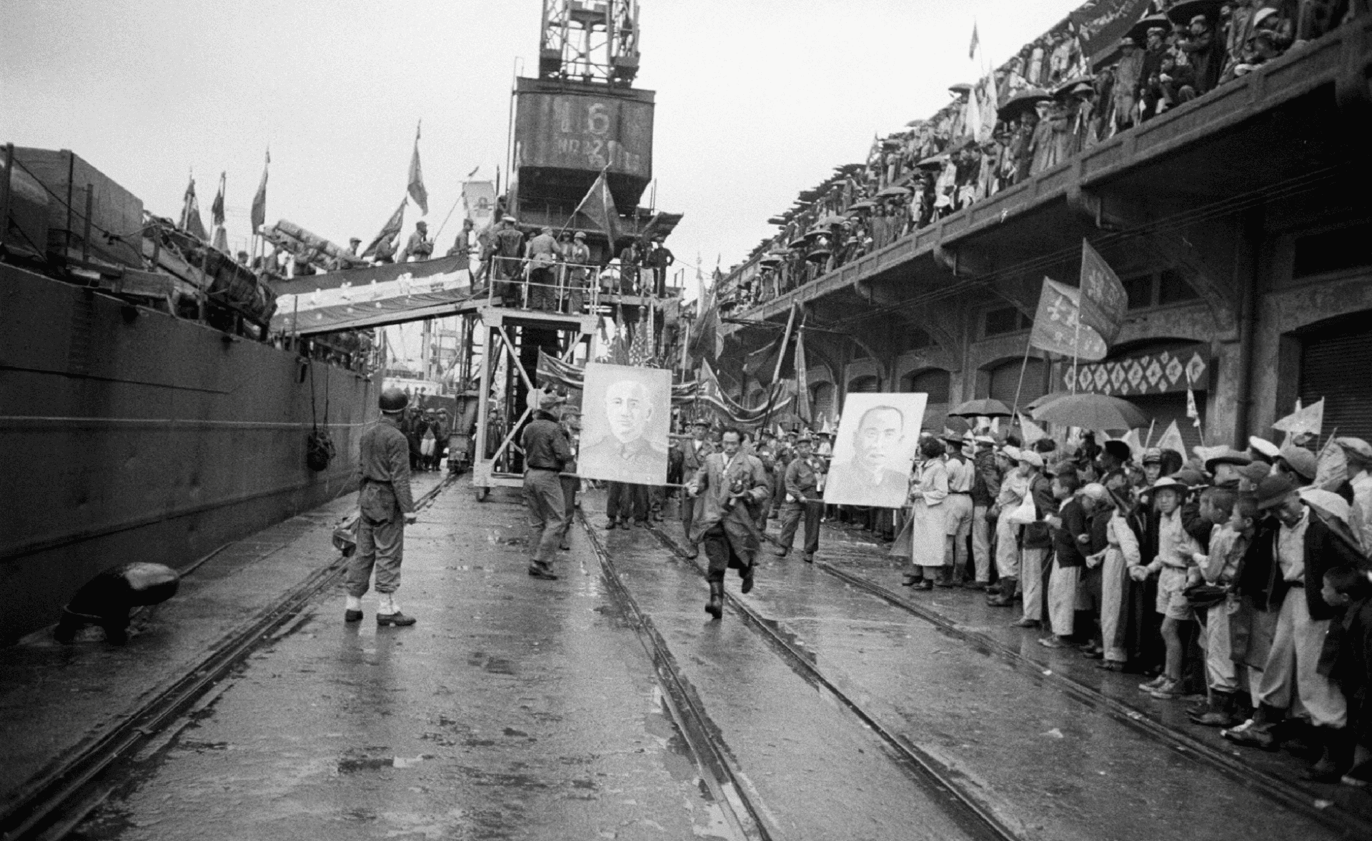迎接來臺的韓戰「反共義士」的隊伍，拍攝於1950年代的基隆港，可以看到大幅的孫文與蔣介石畫像作為遊行的道具。（Life photo collection）