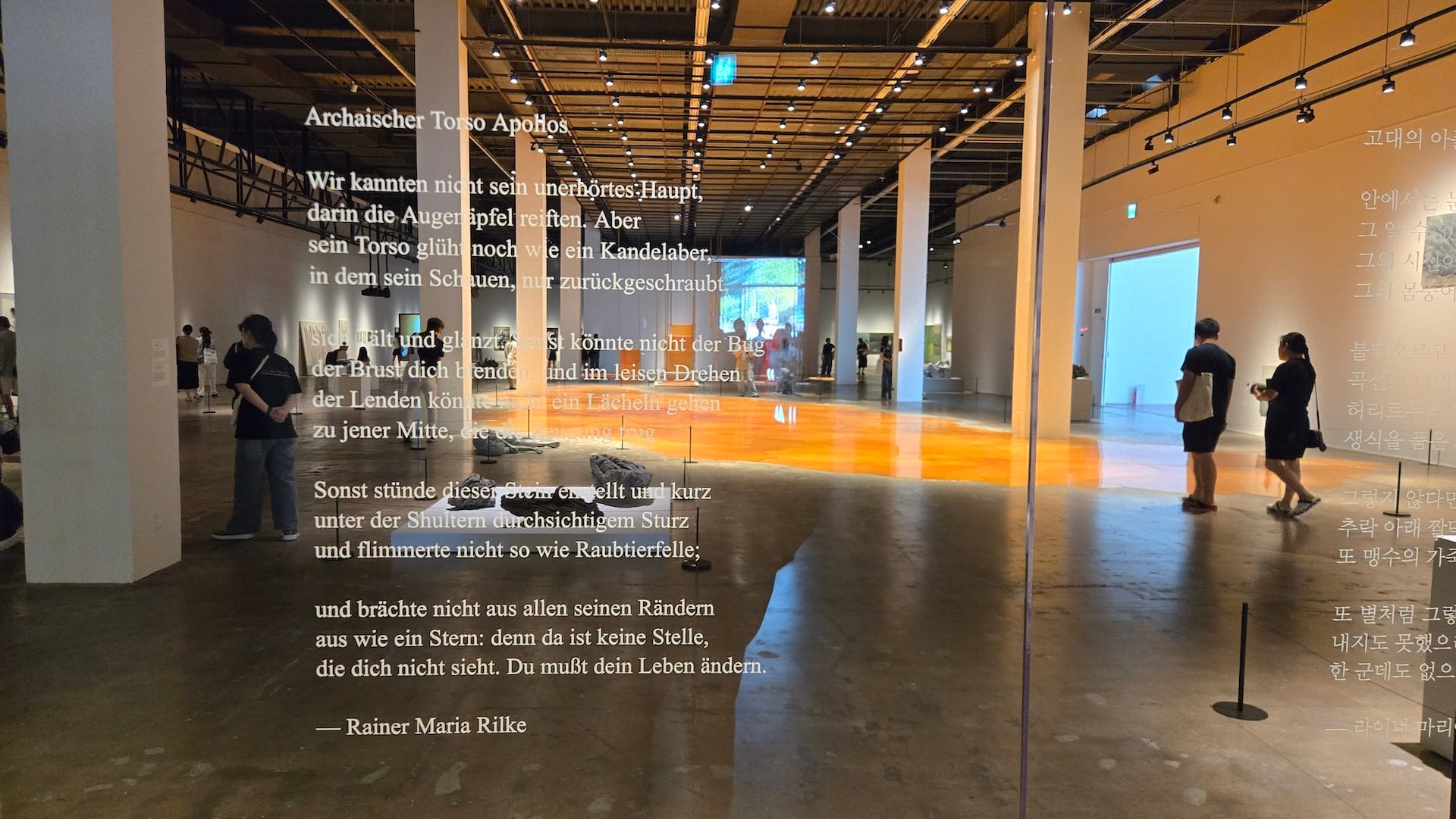光州雙年展G1展廳，里爾克詩文後方展出戈爾丁＋塞內比（Goldin+Senneby）的《松脂池》（Resin Pond，2026）。（攝影／高森信男）